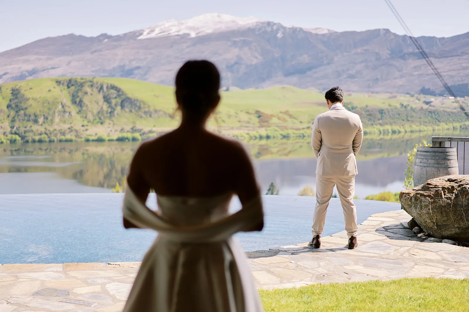 Queenstown Elopement Heli Wedding Photographer クイーンズタウン結婚式 | Ceidi and Tobi, a bride and groom, enjoy a scenic Queenstown wedding ceremony overlooking a serene lake with majestic mountains in the background.