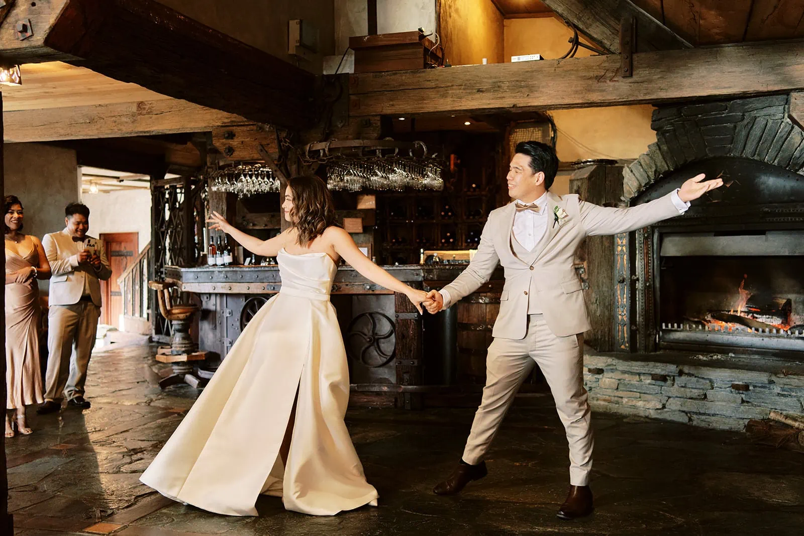 Queenstown Elopement Heli Wedding Photographer クイーンズタウン結婚式 | Tobi and Ceidi, a bride and groom, gracefully dance in front of a fireplace in Queenstown.