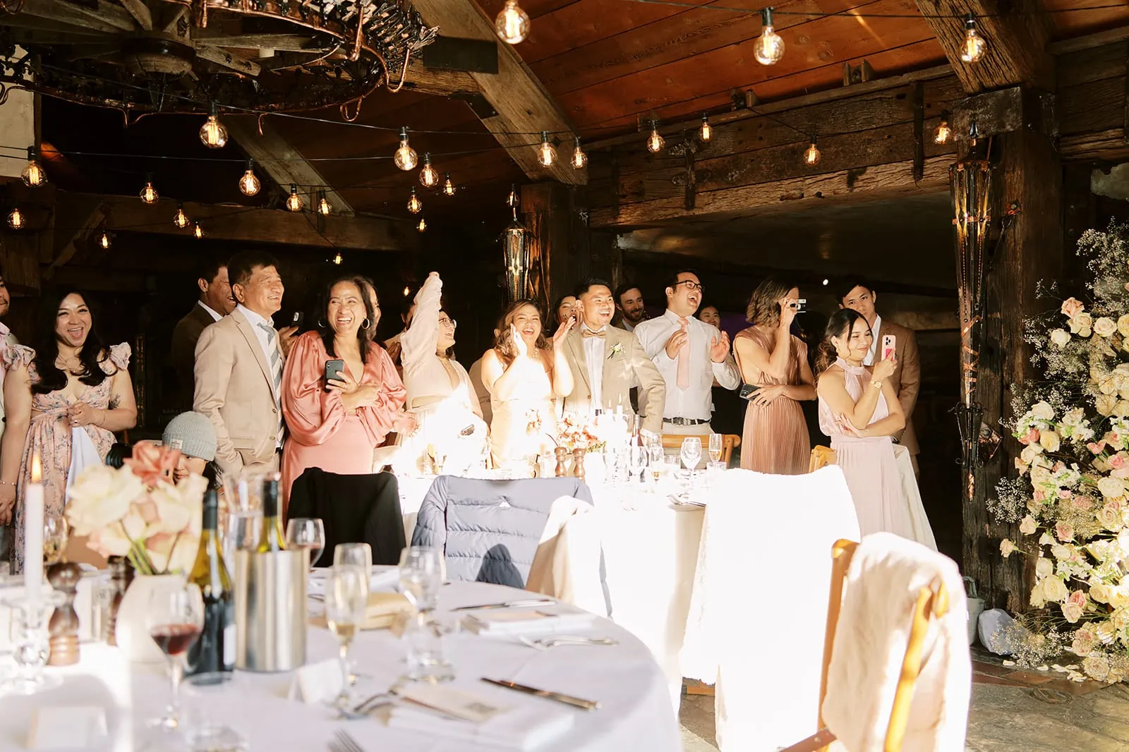 Queenstown Elopement Heli Wedding Photographer クイーンズタウン結婚式 | A group of people standing around a table at a StoneRidge wedding reception.