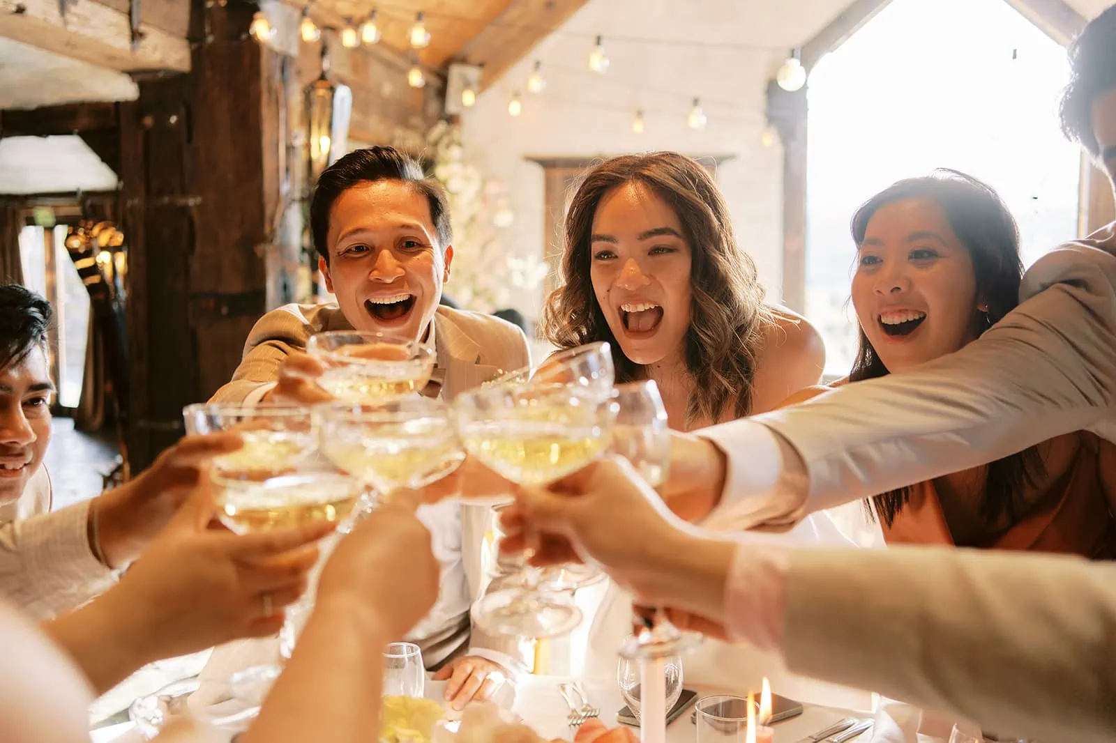 Queenstown Elopement Heli Wedding Photographer クイーンズタウン結婚式 | A group of people toasting wine glasses at a wedding in Queenstown.