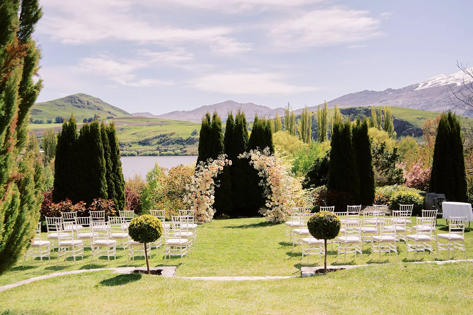 Queenstown Elopement Heli Wedding Photographer クイーンズタウン結婚式 | A Ceidi wedding ceremony set up in a garden with mountains in the background.