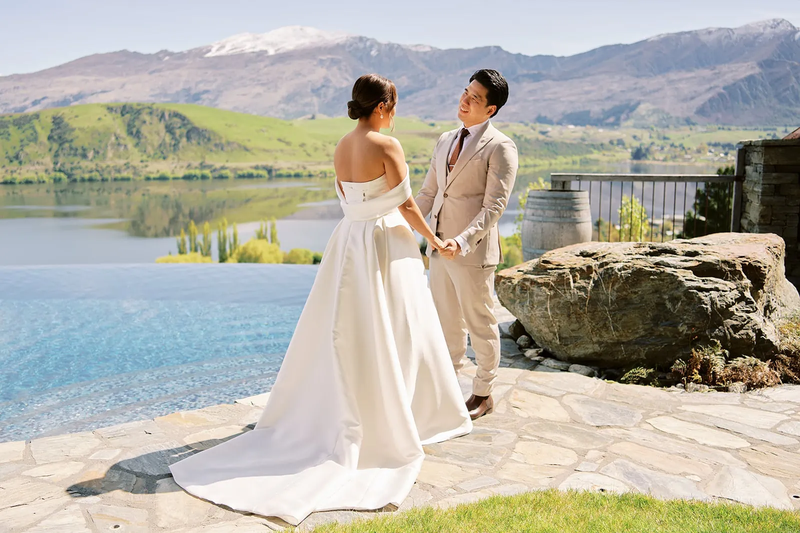 Queenstown Elopement Heli Wedding Photographer クイーンズタウン結婚式 | A bride and groom standing in front of a majestic lake with towering mountains as their stunning wedding backdrop.