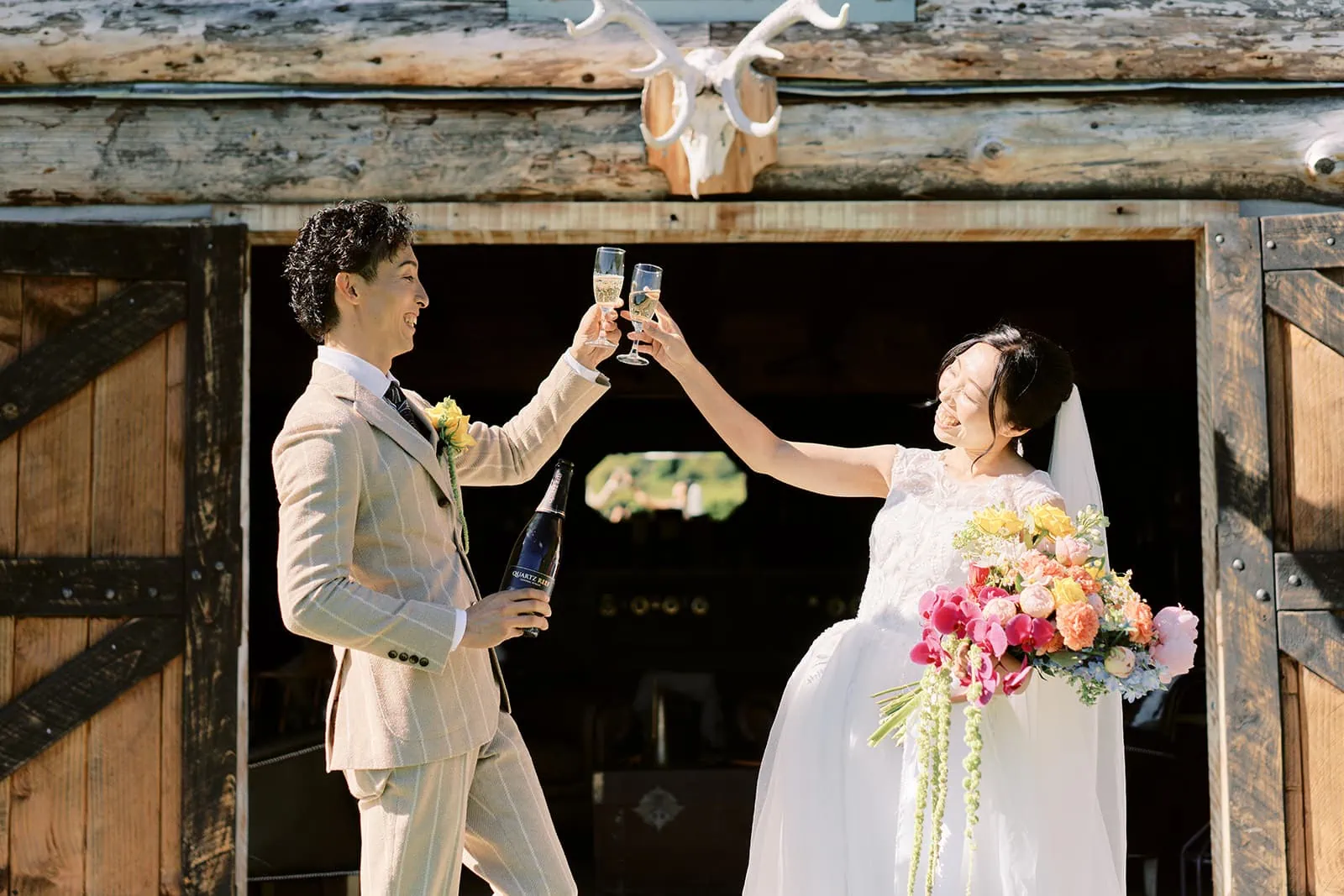 Queenstown Elopement Heli Wedding Photographer クイーンズタウン結婚式 | Saki and Taisei toasting in front of a barn in Queenstown.
