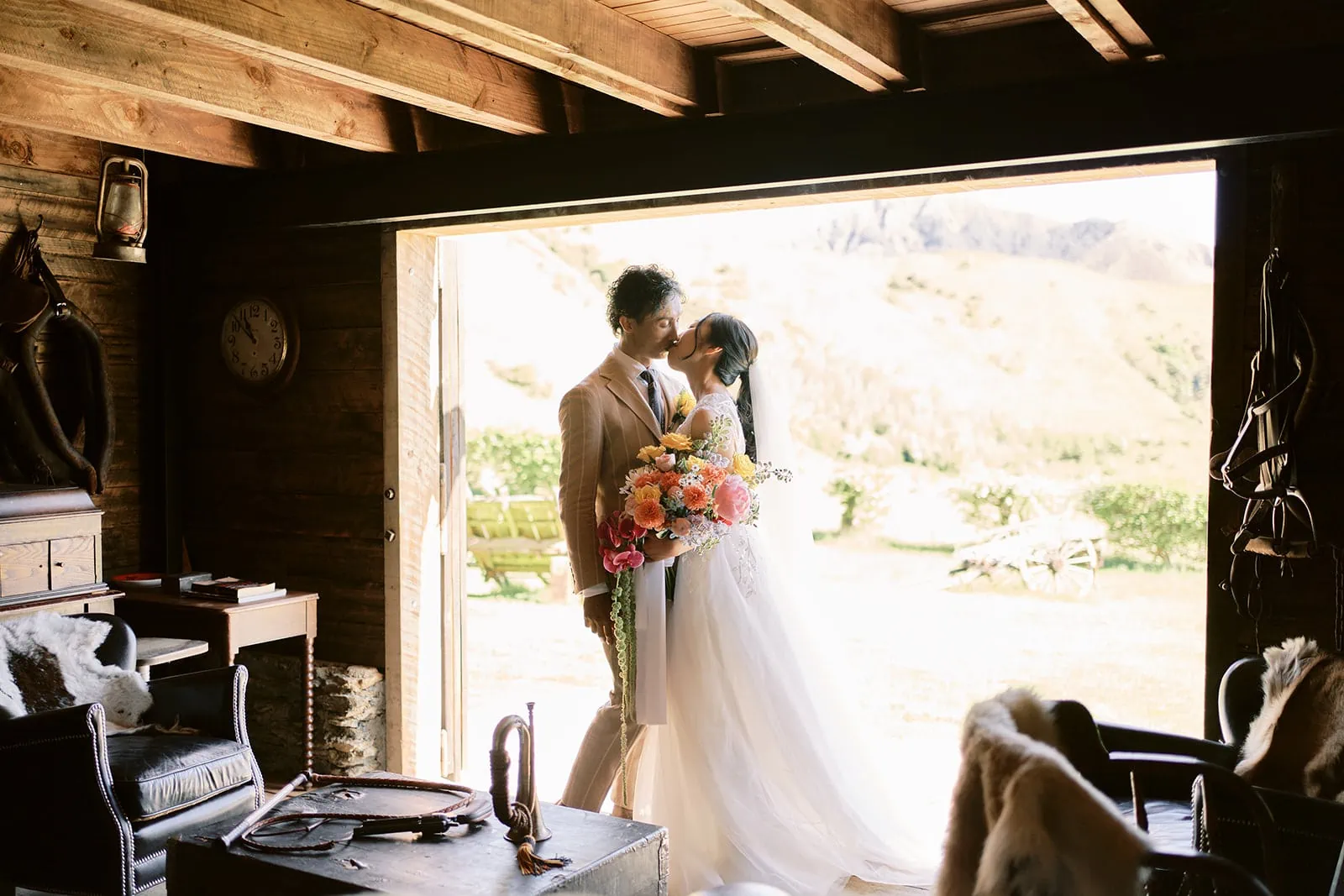 Queenstown Elopement Heli Wedding Photographer クイーンズタウン結婚式 | A Pre-Wedding couple sharing a romantic kiss in the doorway of a Queenstown cabin.