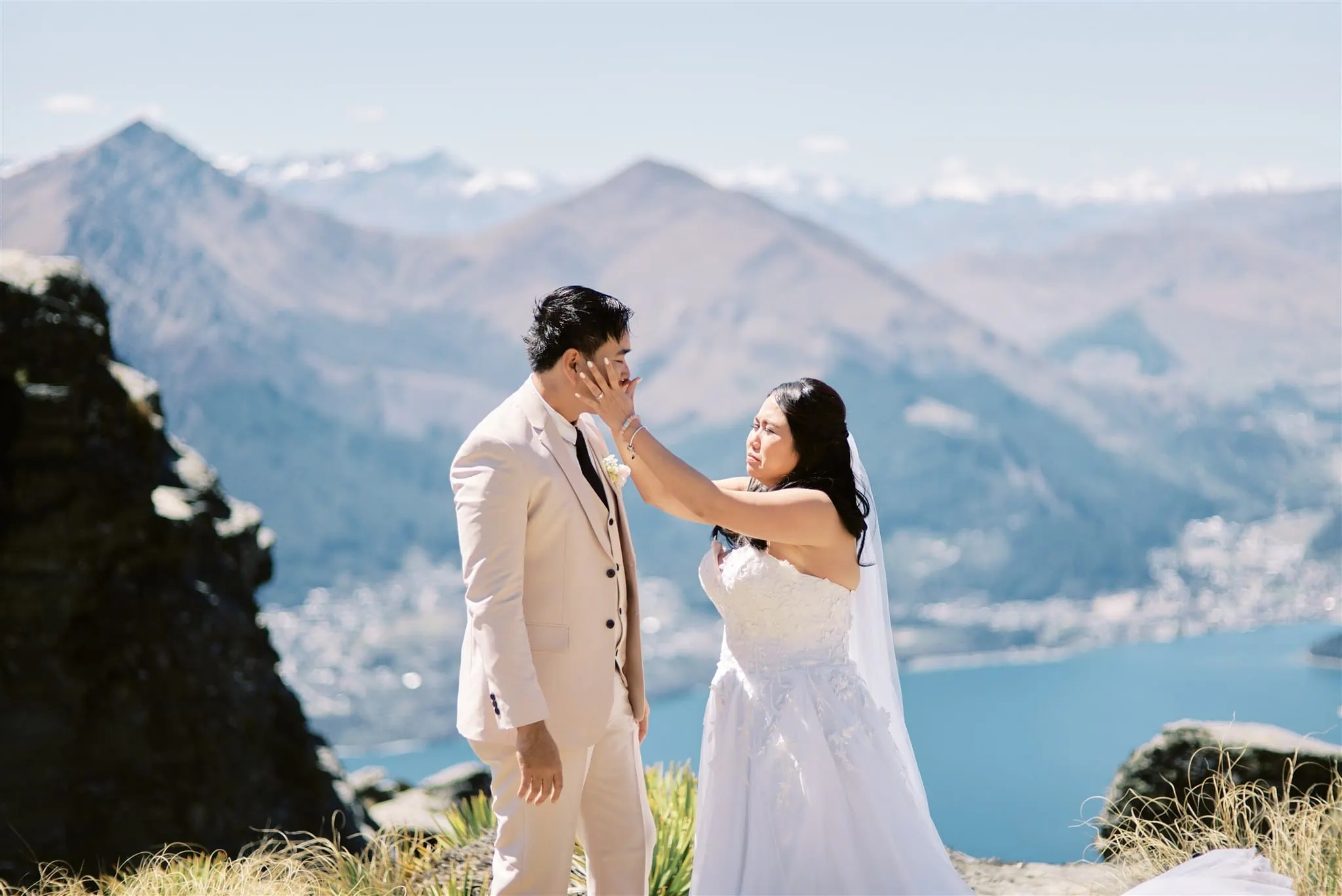 Queenstown Elopement Heli Wedding Photographer クイーンズタウン結婚式 | A man and woman embracing on a mountain peak during their Queenstown elopement.