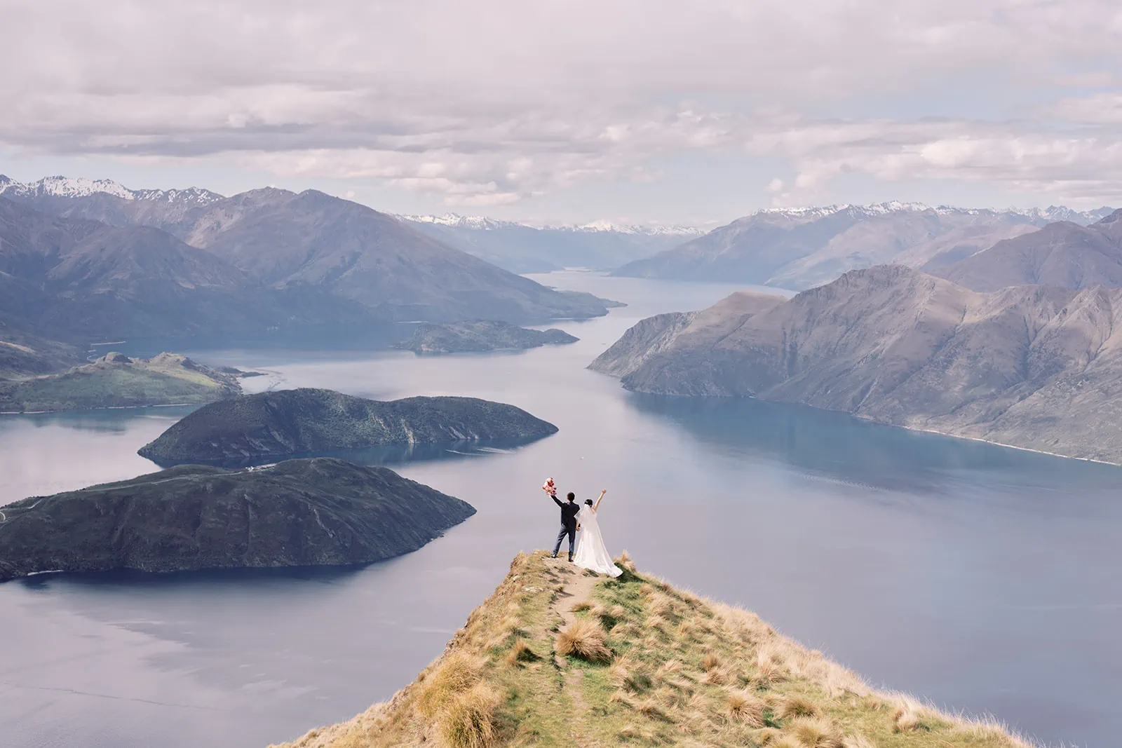 Queenstown Elopement Heli Wedding Photographer クイーンズタウン結婚式 | A couple's pre-wedding photoshoot takes them to the top of a mountain, offering breathtaking views of Lake Wanaka.