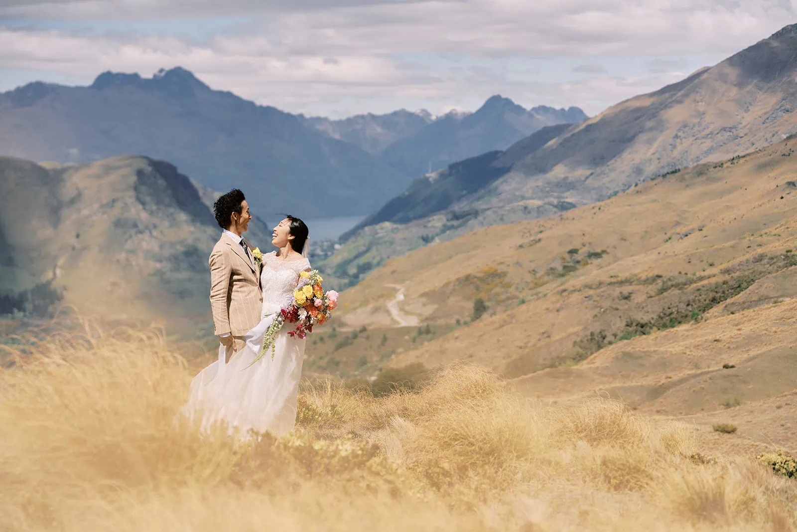 Queenstown Elopement Heli Wedding Photographer クイーンズタウン結婚式 | Saki and Taisei enjoying a Queenstown Heli Pre-Wedding Photoshoot, standing on top of a hill in the mountains.