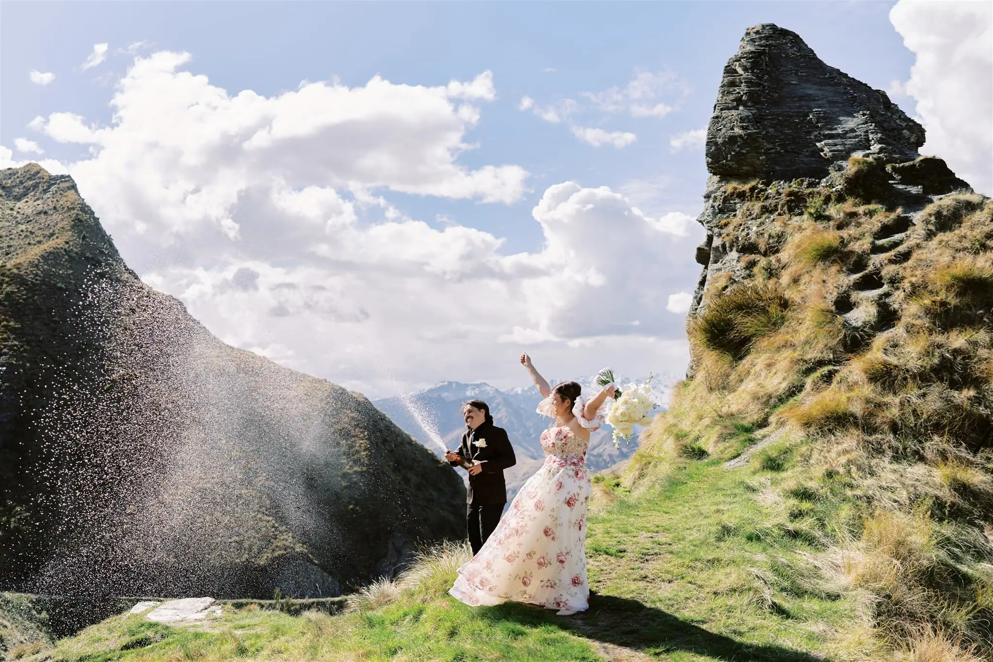 Queenstown Elopement Heli Wedding Photographer クイーンズタウン結婚式 | A Coronet Peak elopement captures a breathtaking moment of a bride and groom standing on a rocky hillside.