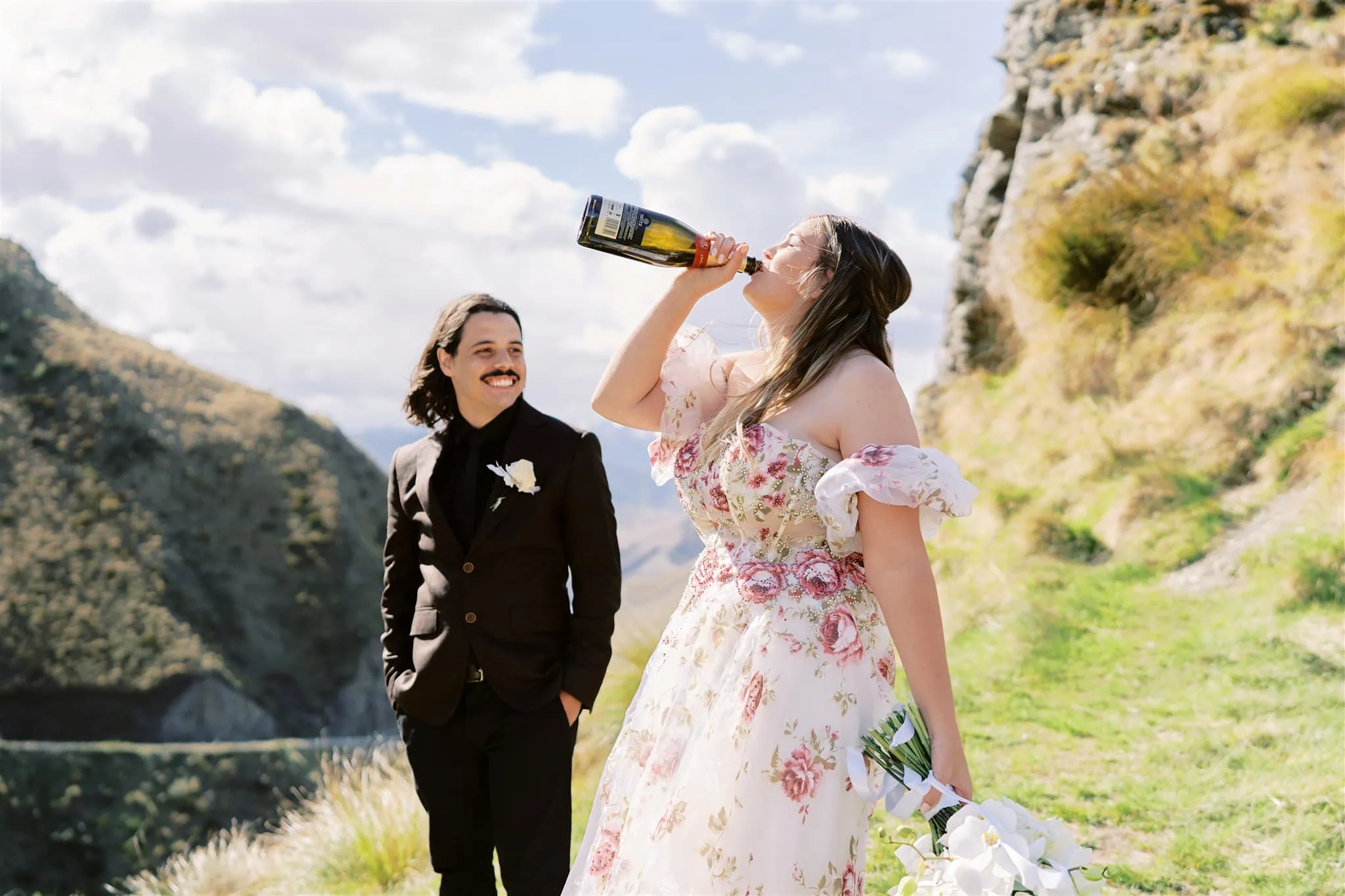 Queenstown Elopement Heli Wedding Photographer クイーンズタウン結婚式 | A couple enjoying a Coronet Peak elopement, sipping from a bottle.