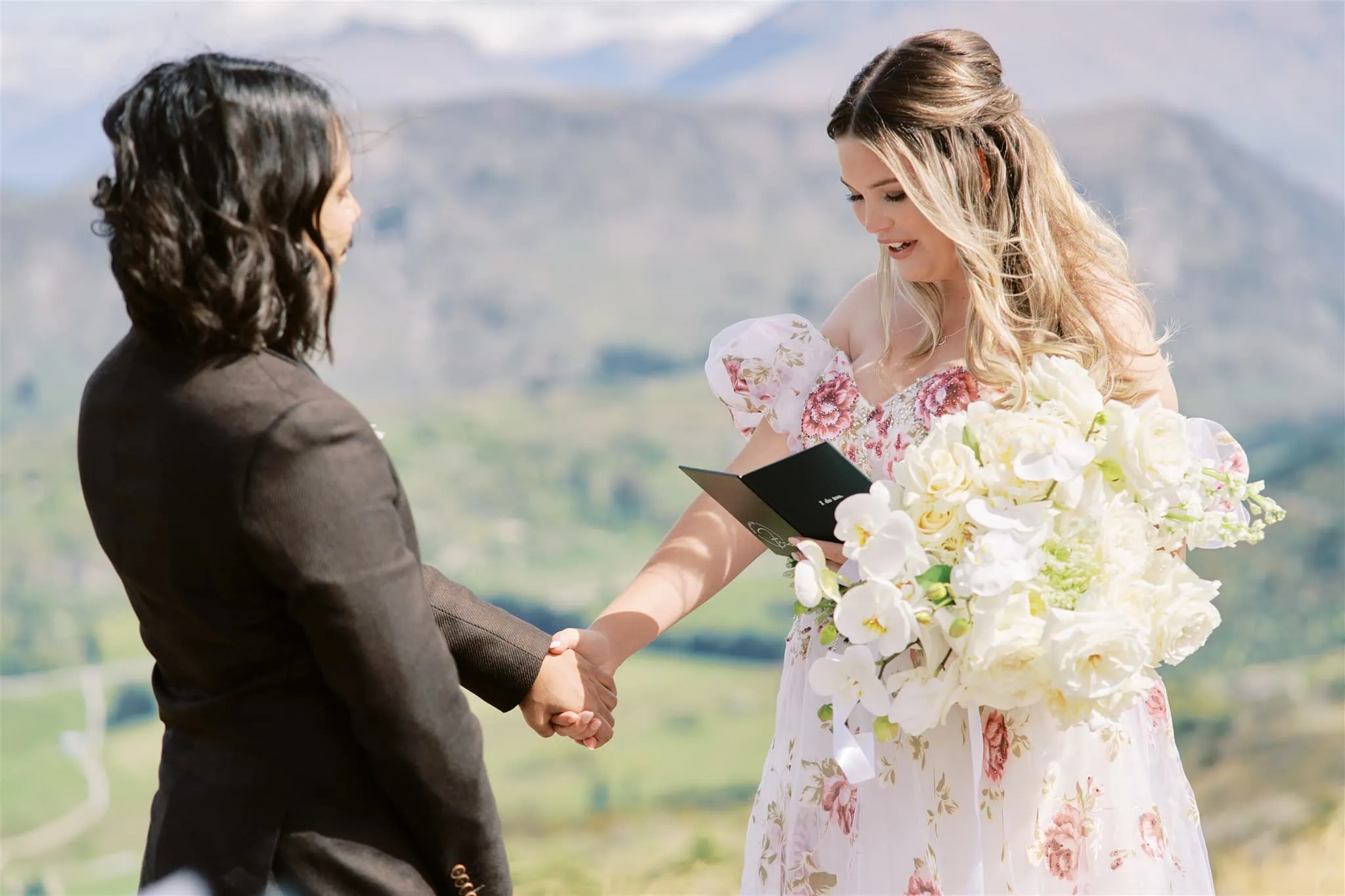 Queenstown Elopement Heli Wedding Photographer クイーンズタウン結婚式 | A couple, at Coronet Peak, holding hands during their elopement ceremony.