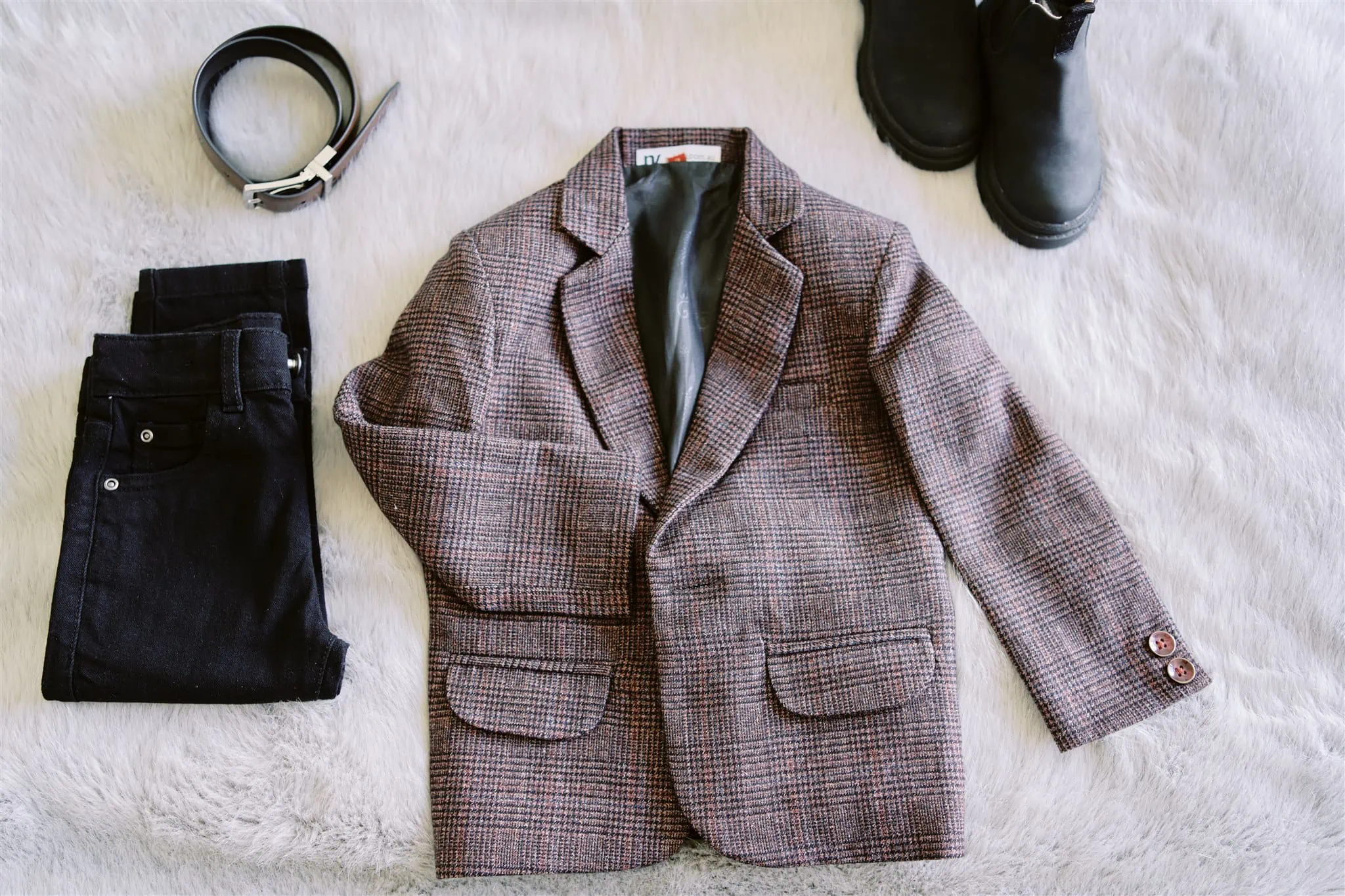 Queenstown Elopement Heli Wedding Photographer クイーンズタウン結婚式 | A Coronet Peak elopement features a stunning couple wearing a jacket and pants gracefully posed on a luxurious fur surface.