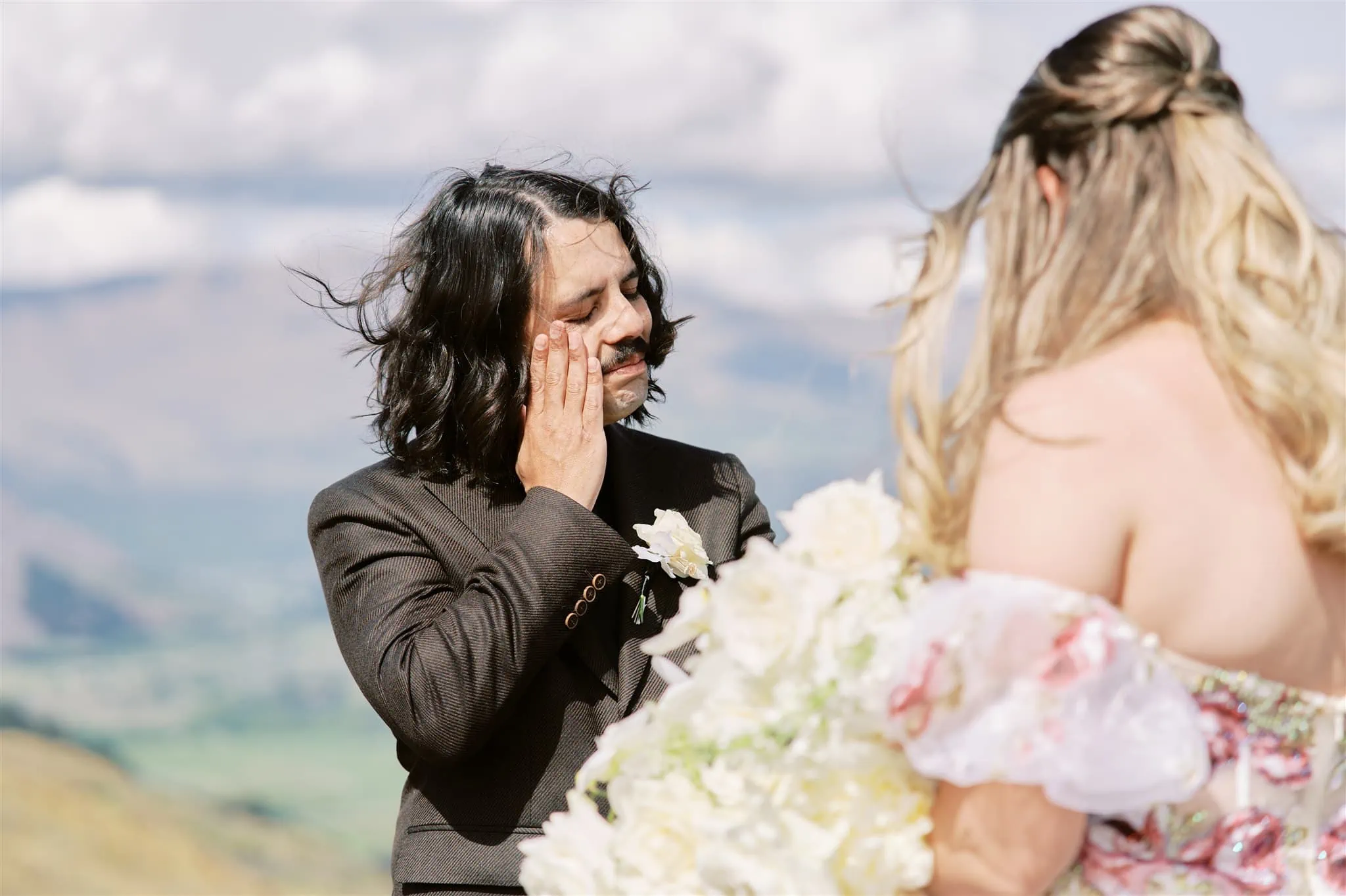 Queenstown Elopement Heli Wedding Photographer クイーンズタウン結婚式 | A man touching his face while another man looks at the woman during a Coronet Peak elopement.