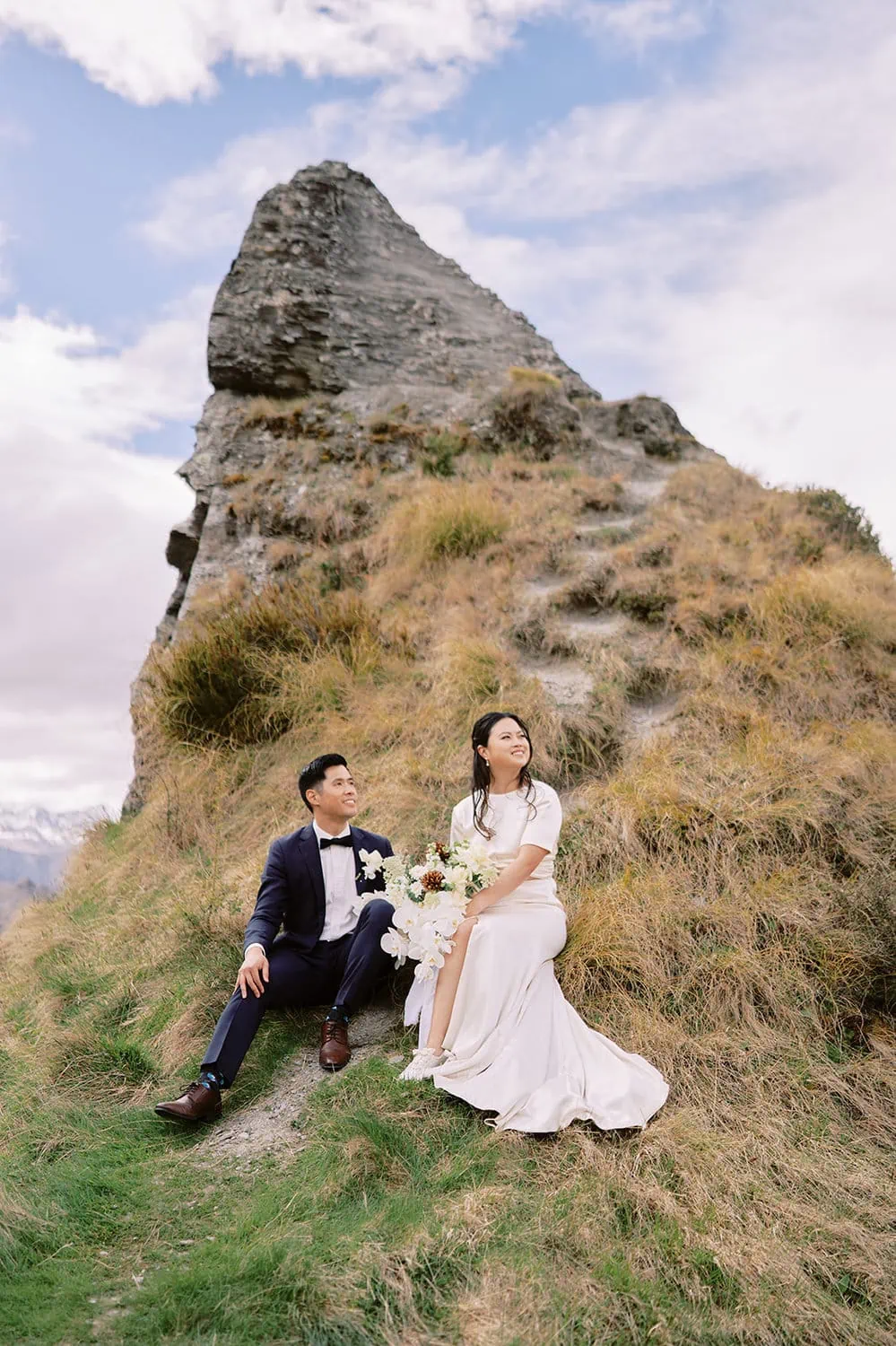 Queenstown Elopement Heli Wedding Photographer クイーンズタウン結婚式 | A couple sitting on a hill during their pre-wedding photoshoot.