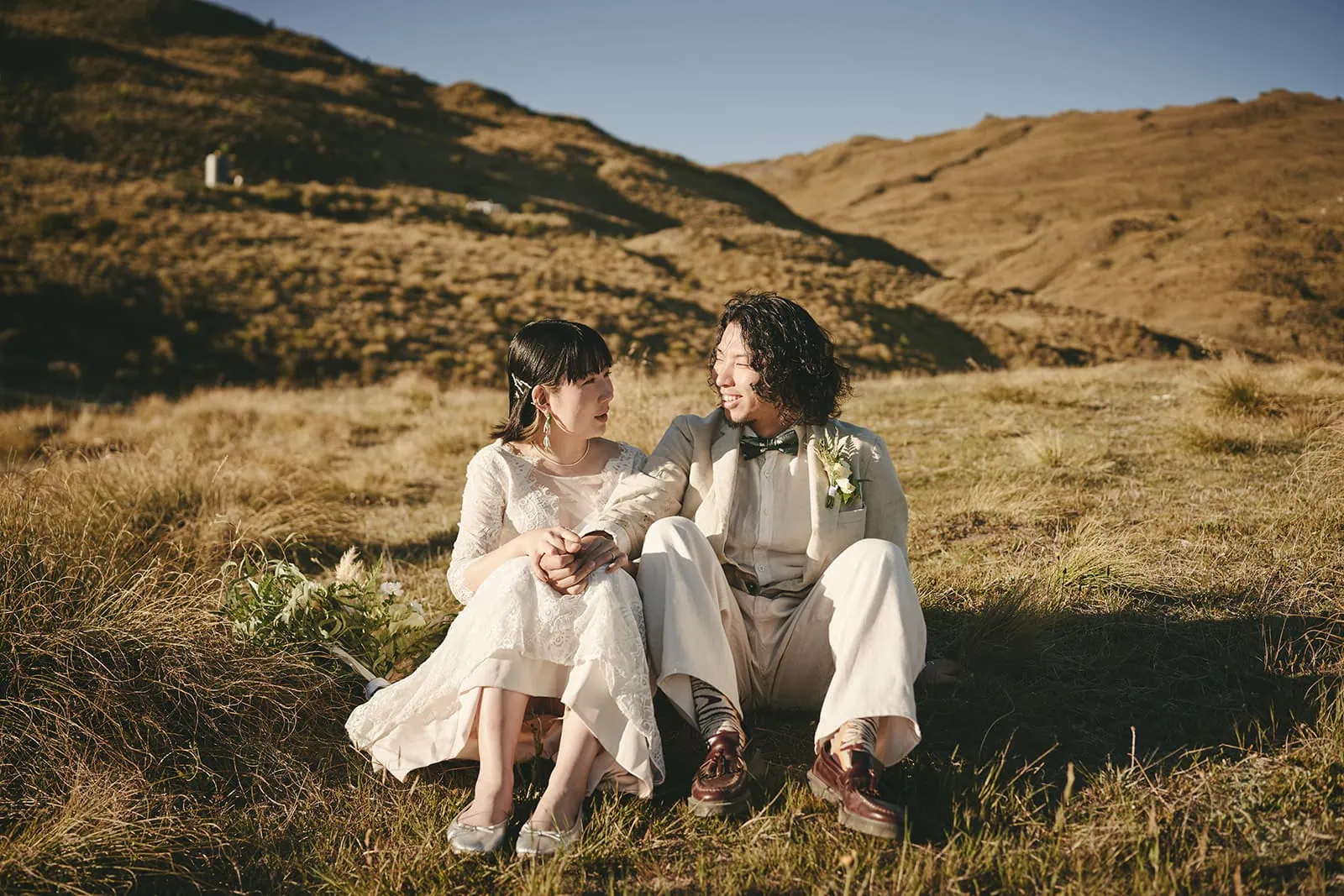 Queenstown Elopement Heli Wedding Photographer クイーンズタウン結婚式 | Eriko and Naoki, a couple from Queenstown, captured their love with a stunning pre-wedding shoot in a serene grassy field.