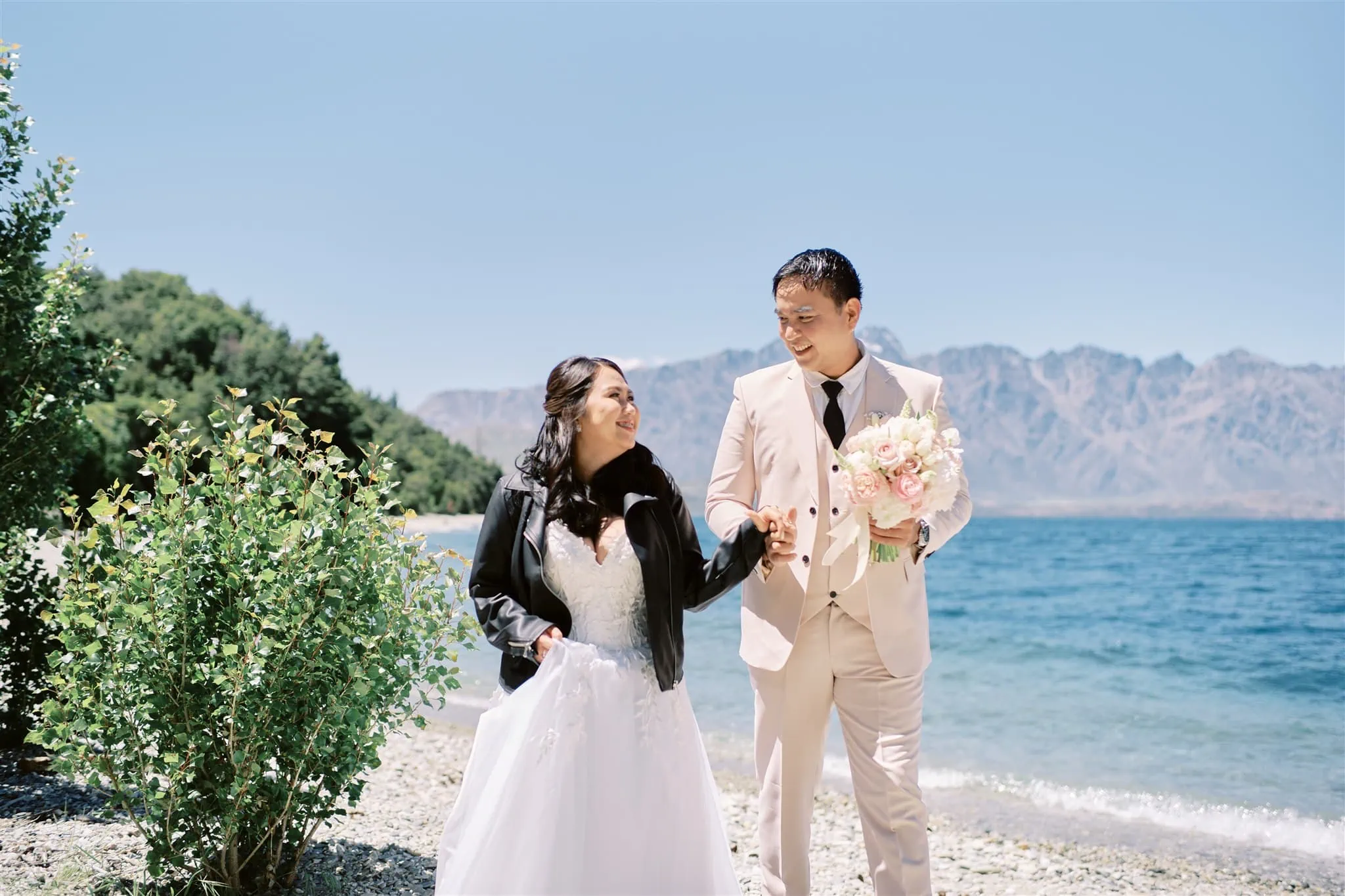 Queenstown Elopement Heli Wedding Photographer クイーンズタウン結婚式 | A Queenstown elopement - a bride and groom walking along the shore of Lake Wanaka.