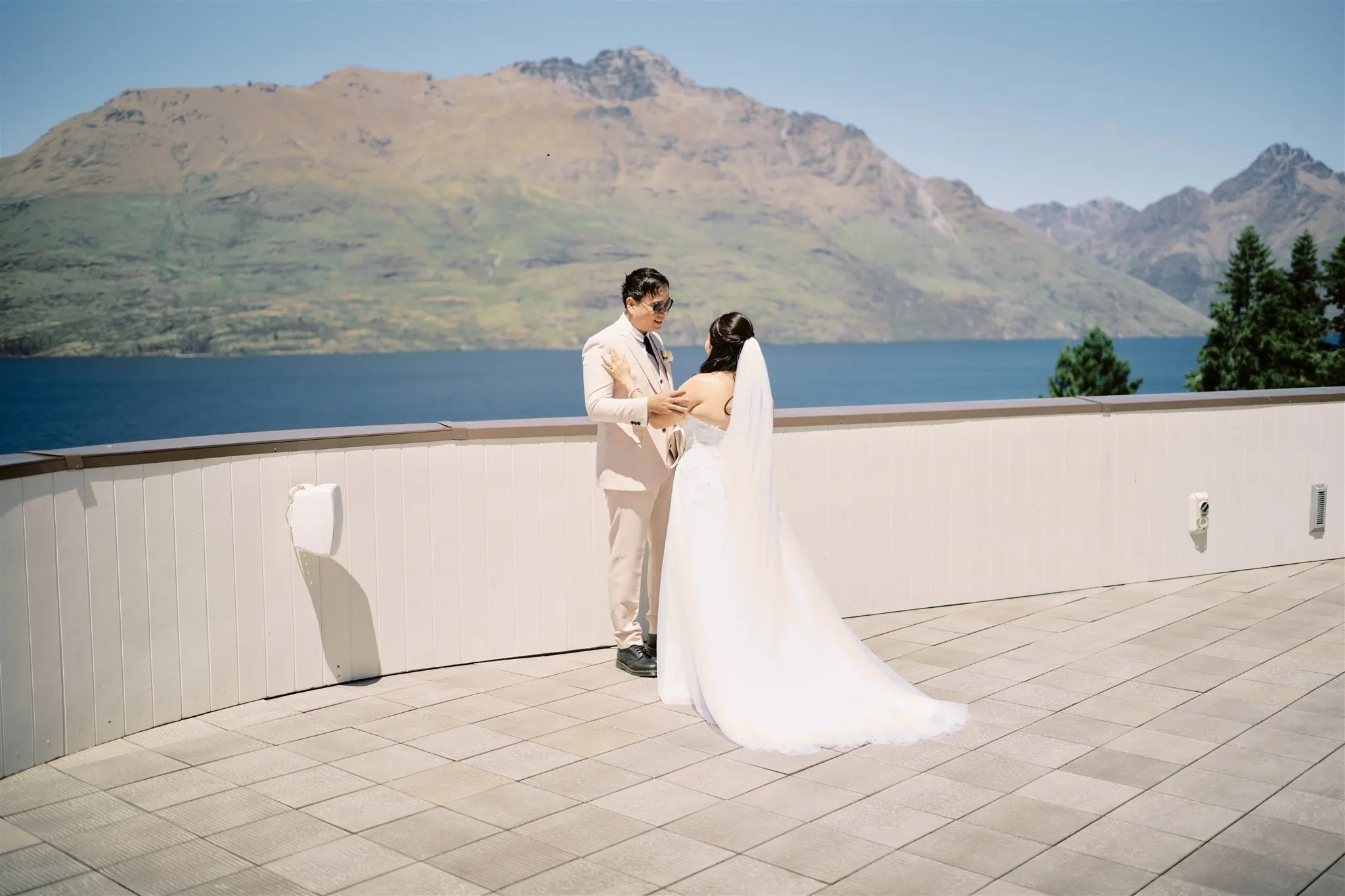 Queenstown Elopement Heli Wedding Photographer クイーンズタウン結婚式 | A Queenstown elopement with a bride and groom standing on a balcony overlooking Lake Wanaka.