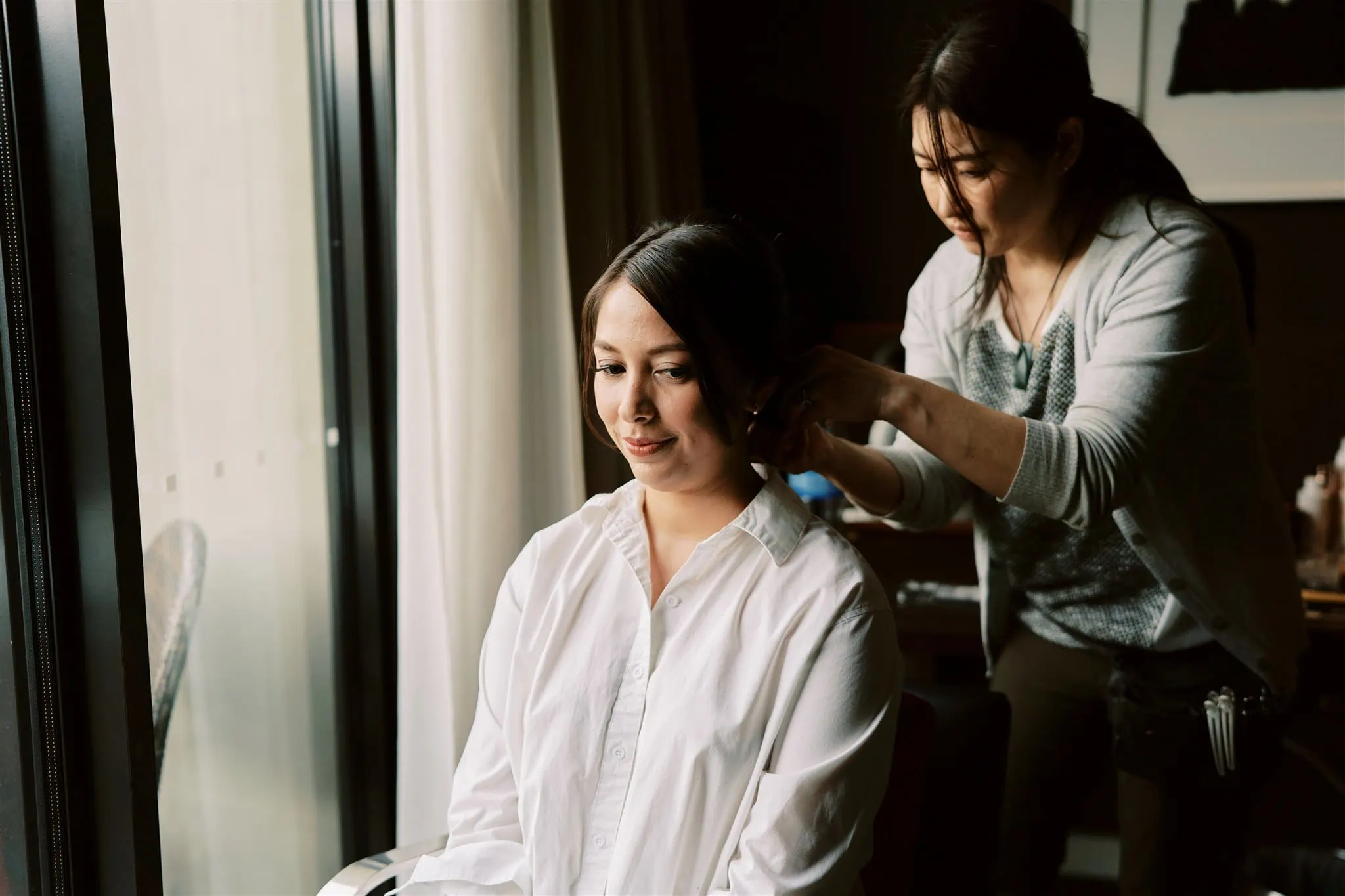 Queenstown Elopement Heli Wedding Photographer クイーンズタウン結婚式 | Mariah, a woman in Queenstown, is getting her hair done by Cliff, a hairdresser.