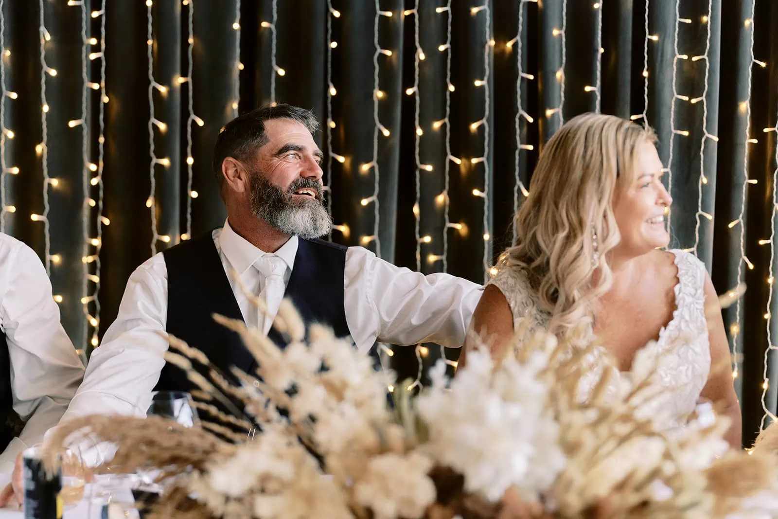 Queenstown Elopement Heli Wedding Photographer クイーンズタウン結婚式 | Melissa & Scott, a bride and groom, share an exuberant moment of laughter at their wedding reception held at Kamana Lakehouse in Queenstown.