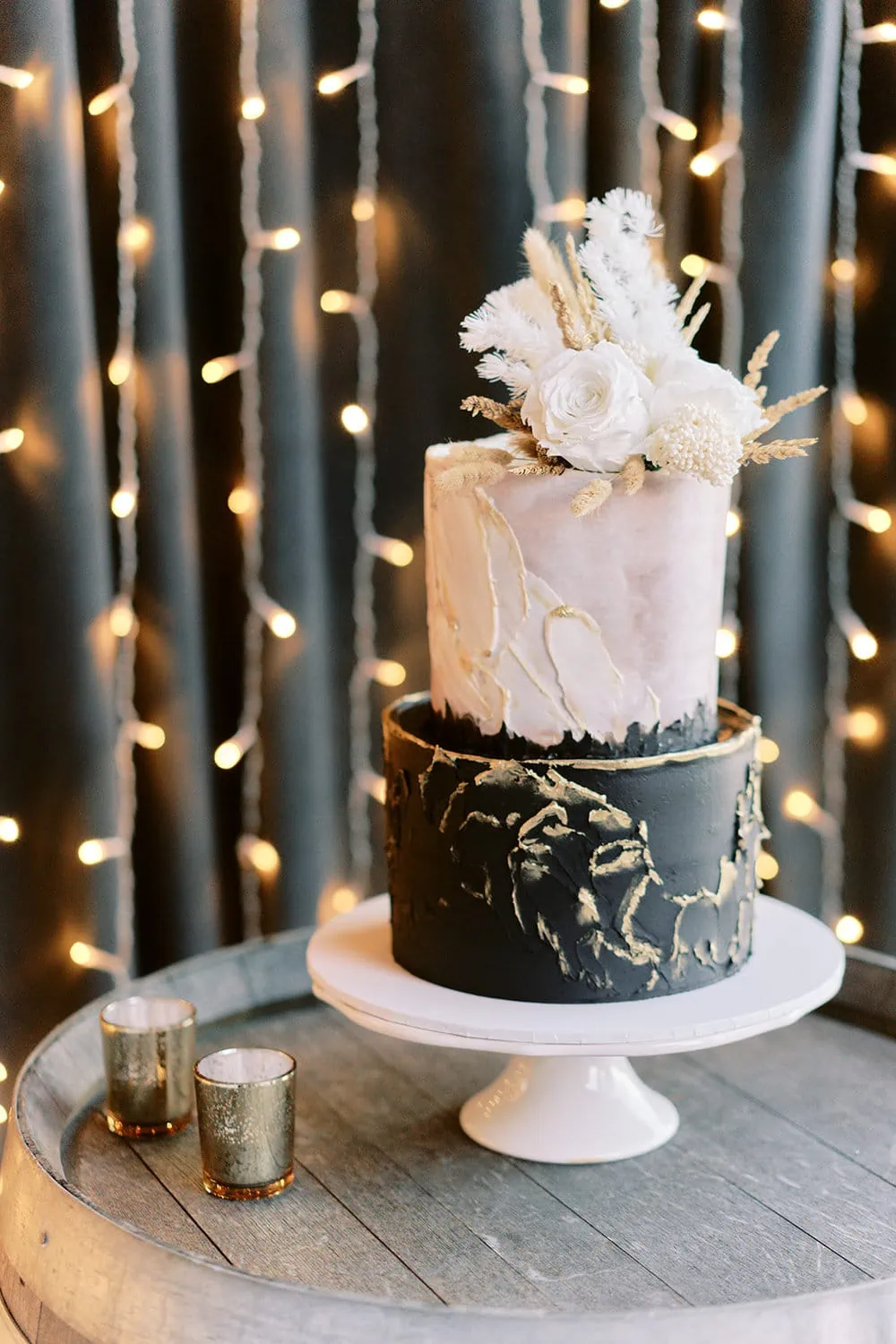 Queenstown Elopement Heli Wedding Photographer クイーンズタウン結婚式 | Melissa and Scott's black and gold wedding cake sits on a wooden table at Kamana Lakehouse.