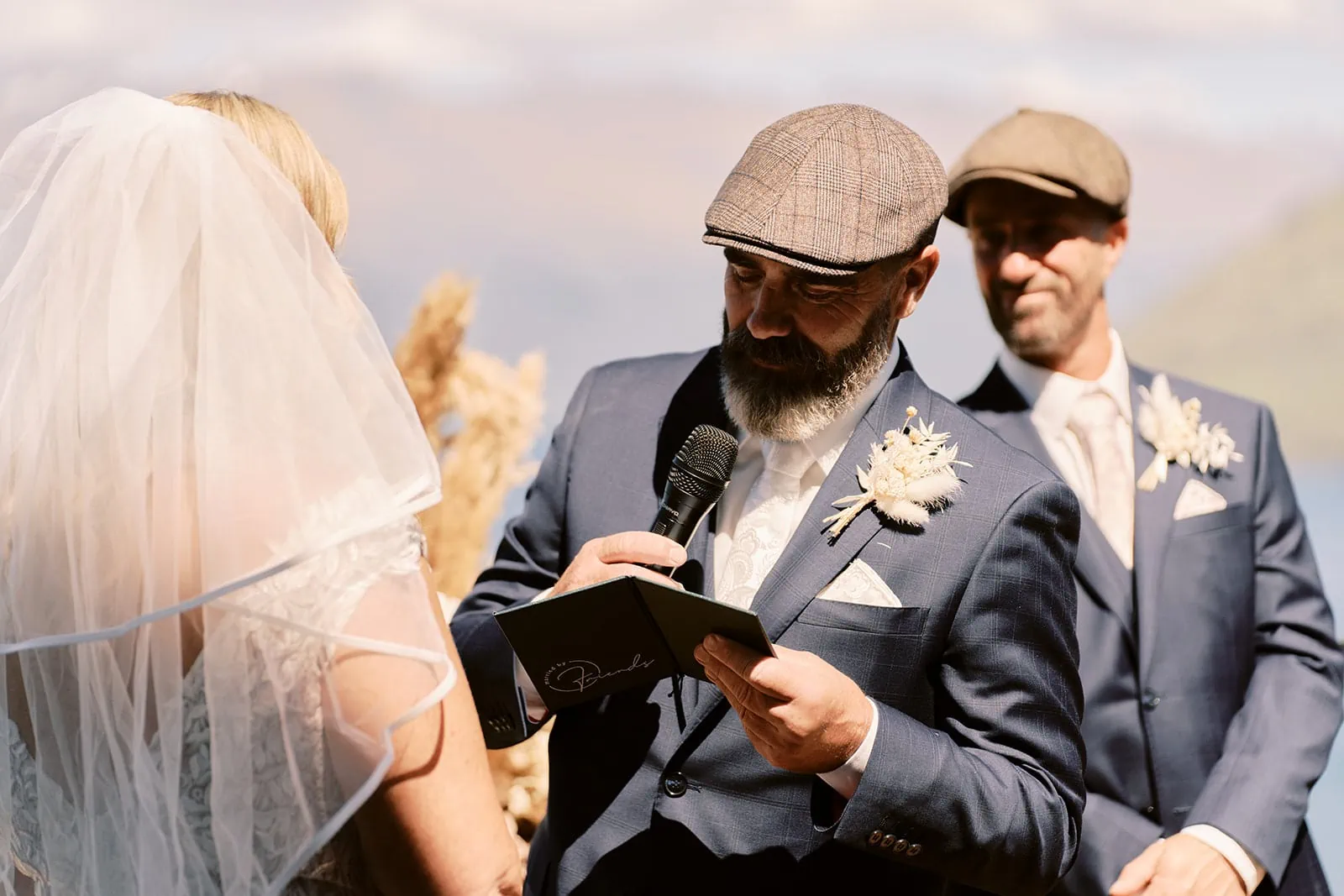 Queenstown Elopement Heli Wedding Photographer クイーンズタウン結婚式 | Melissa and Scott, a bride and groom, reading their vows in front of Kamana Lakehouse in Queenstown.