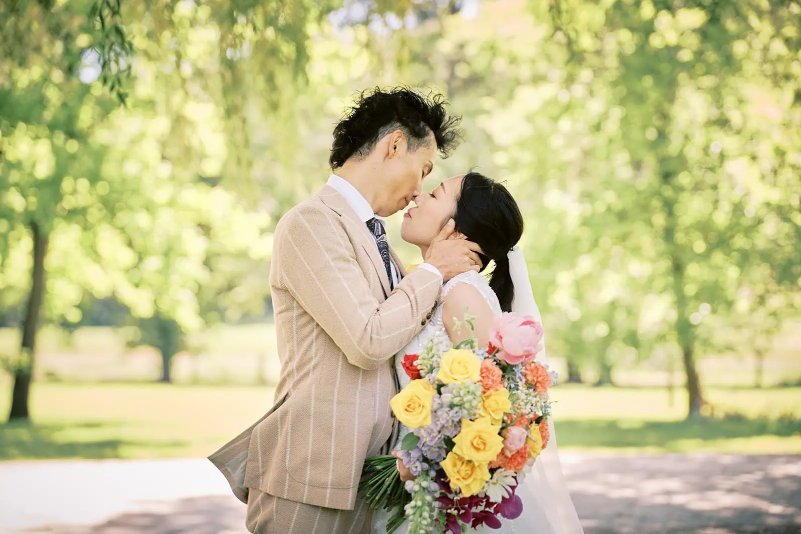 Queenstown Elopement Heli Wedding Photographer クイーンズタウン結婚式 | Taisei and Saki, the bride and groom, sharing a loving kiss in Queenstown's beautiful park.