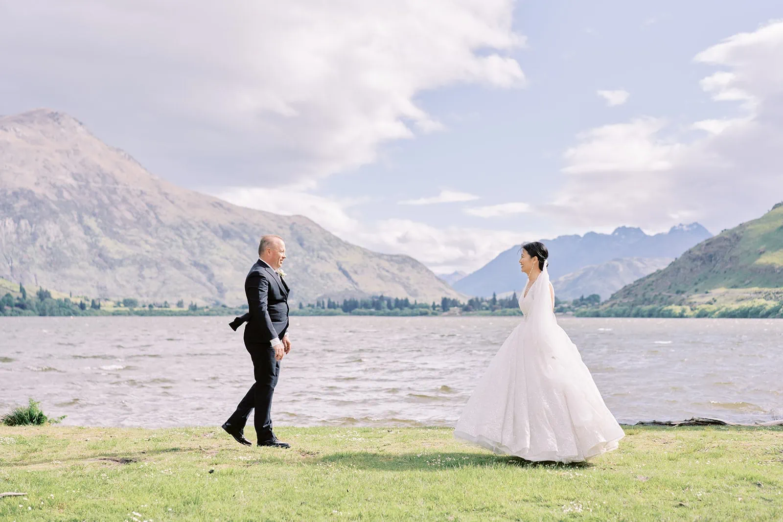 Queenstown Elopement Heli Wedding Photographer クイーンズタウン結婚式 | Meng and Joel, a bride and groom, standing in front of Stoneridge Estate, a picturesque lakefront venue in New Zealand.