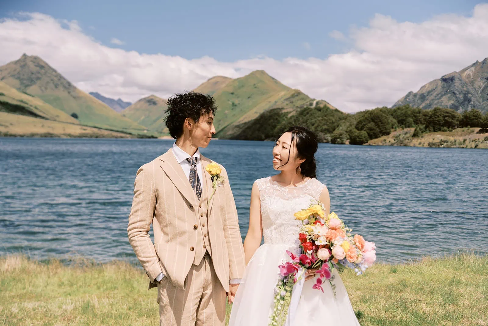 Queenstown Elopement Heli Wedding Photographer クイーンズタウン結婚式 | Queenstown Heli Pre-Wedding Photoshoot with a bride and groom standing in front of a lake.
