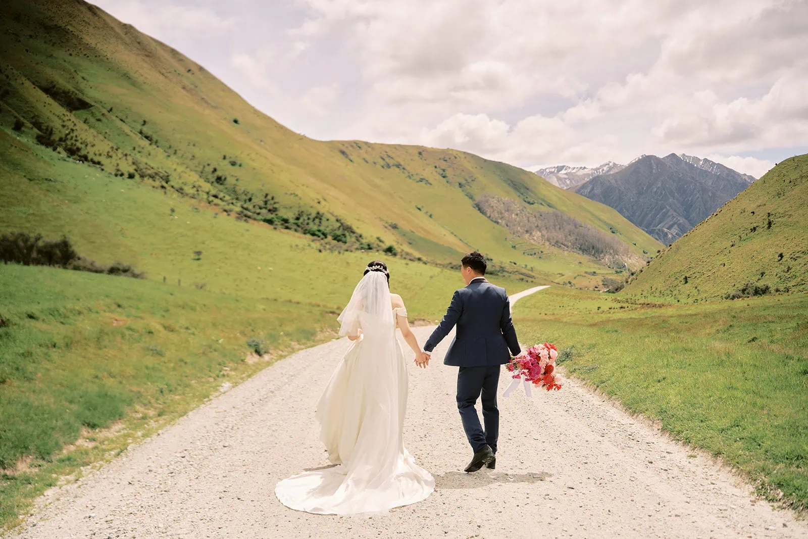 Queenstown Elopement Heli Wedding Photographer クイーンズタウン結婚式 | A bride and groom posing for their pre-wedding photoshoot on a dirt road in the mountains.