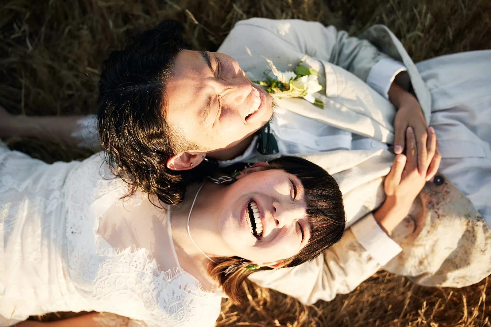Queenstown Elopement Heli Wedding Photographer クイーンズタウン結婚式 | A bride and groom laying in a field near Queenstown.