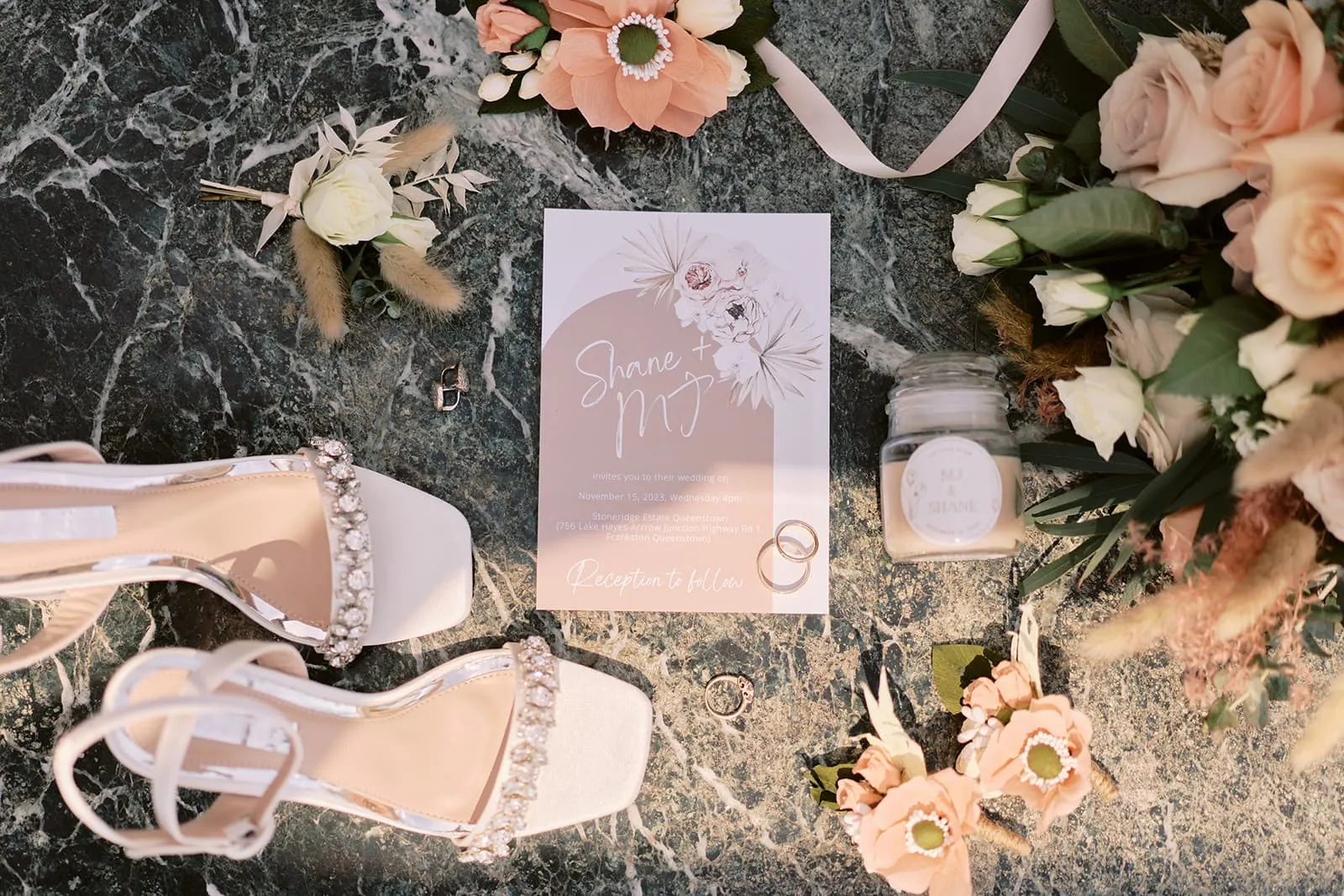 Queenstown Elopement Heli Wedding Photographer クイーンズタウン結婚式 | Mj & Shane's Stoneridge Queenstown Wedding showcases a stunning bouquet of flowers and elegant wedding shoes displayed on a beautiful marble table.