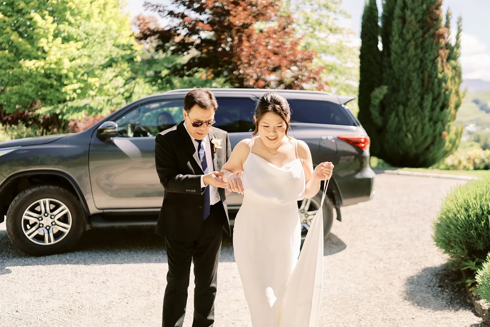 Queenstown Elopement Heli Wedding Photographer クイーンズタウン結婚式 | Mj & Shane, a bride and groom, standing next to a suv at their Stoneridge Queenstown Wedding.