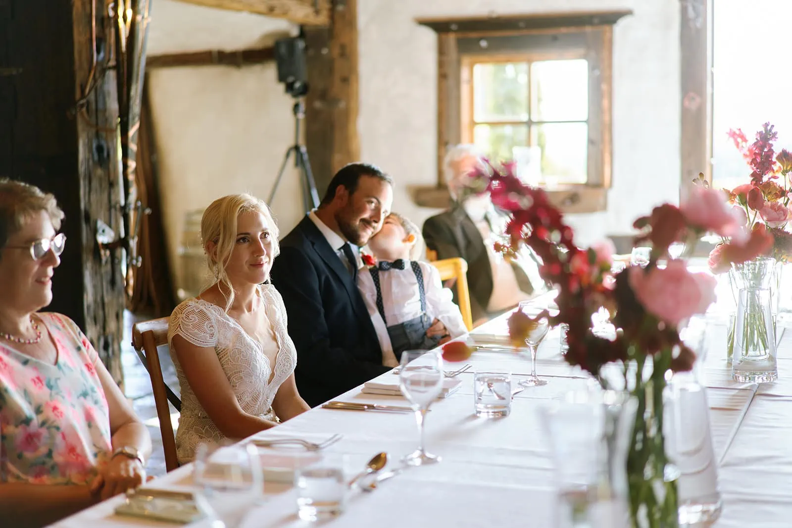 Queenstown Elopement Heli Wedding Photographer クイーンズタウン結婚式 | A couple, Emily and James, is sitting at a long table at Queenstown Stoneridge Estate.