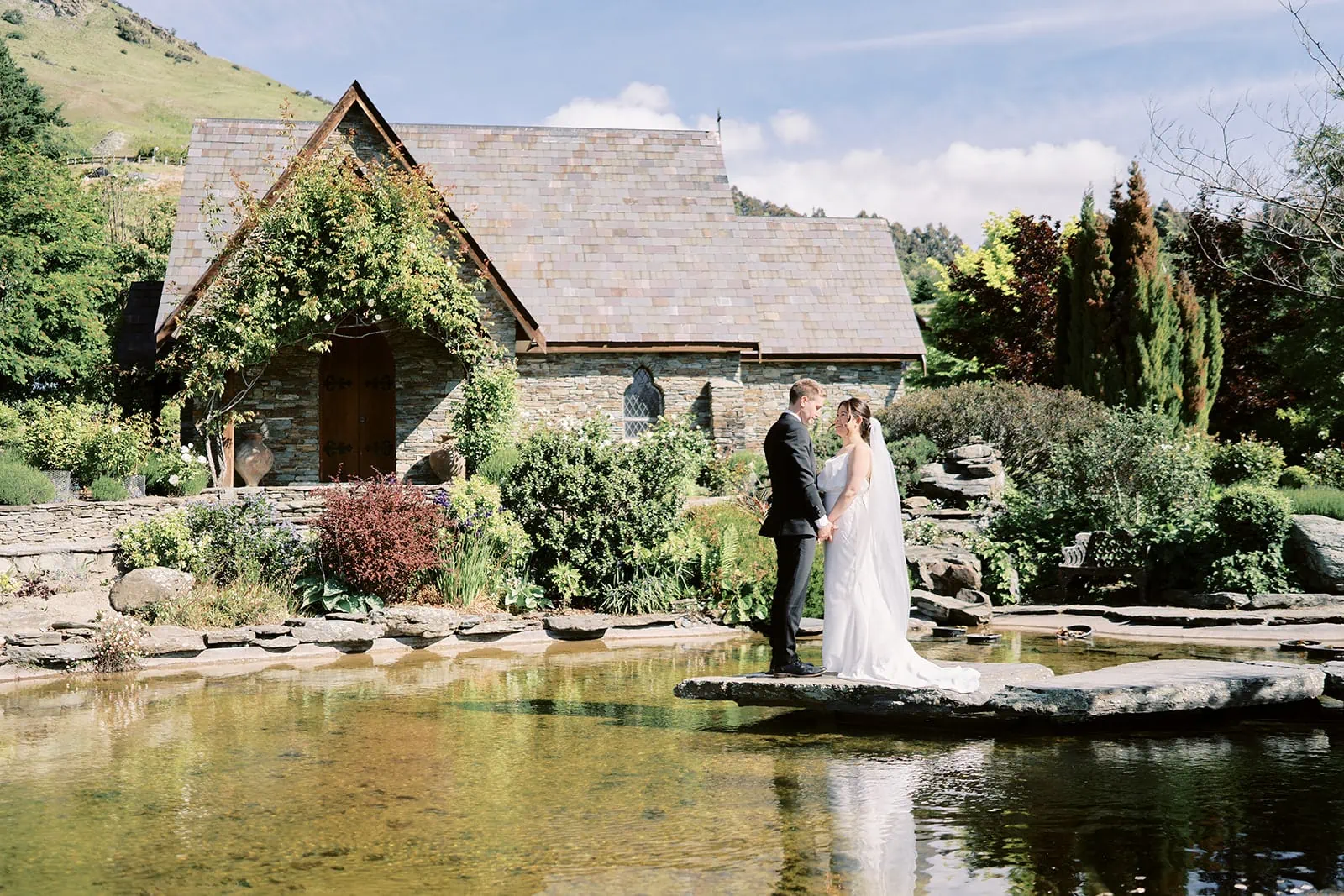 Queenstown Elopement Heli Wedding Photographer クイーンズタウン結婚式 | Wedding couple standing in front of a pond at Stoneridge Queenstown.