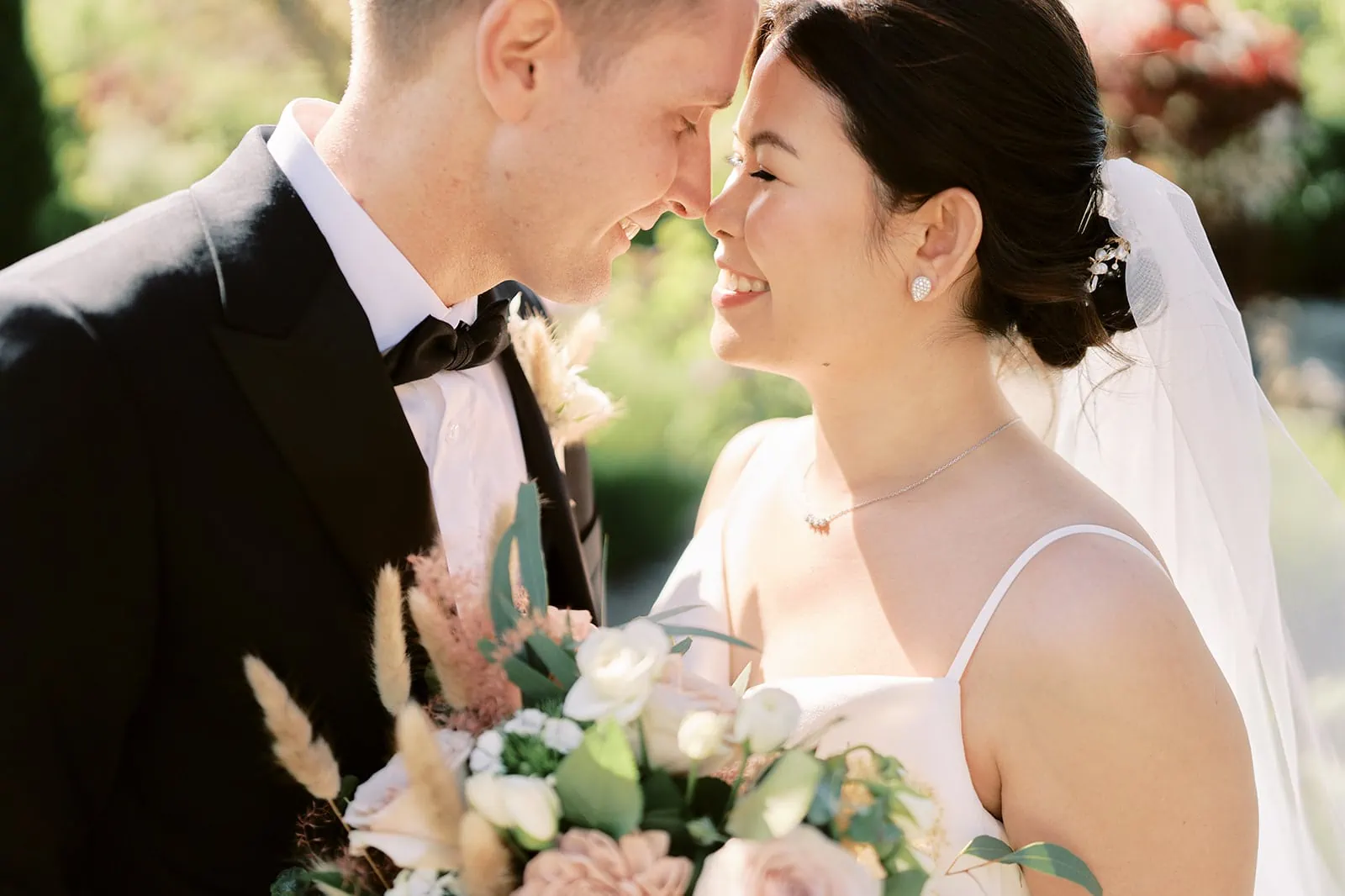 Queenstown Elopement Heli Wedding Photographer クイーンズタウン結婚式 | A Stoneridge Queenstown wedding with the bride and groom sharing a kiss in a beautiful garden setting.