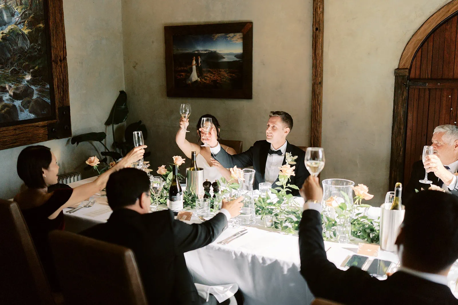 Queenstown Elopement Heli Wedding Photographer クイーンズタウン結婚式 | Wedding guests at Stoneridge Queenstown toasting at a dinner table.