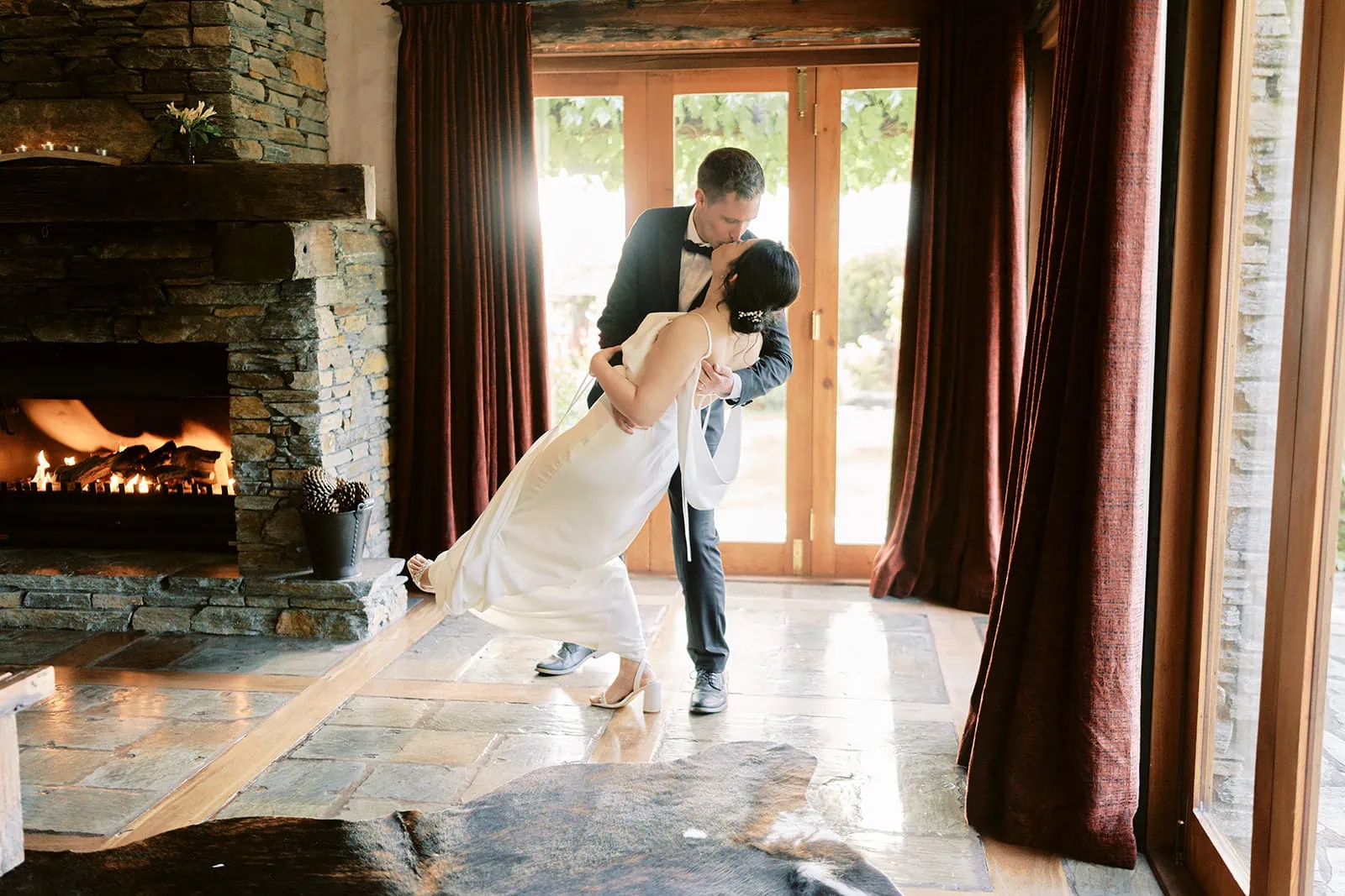 Queenstown Elopement Heli Wedding Photographer クイーンズタウン結婚式 | Mj and Shane, the bride and groom from Stoneridge Queenstown, gracefully dancing in front of a cozy fireplace.