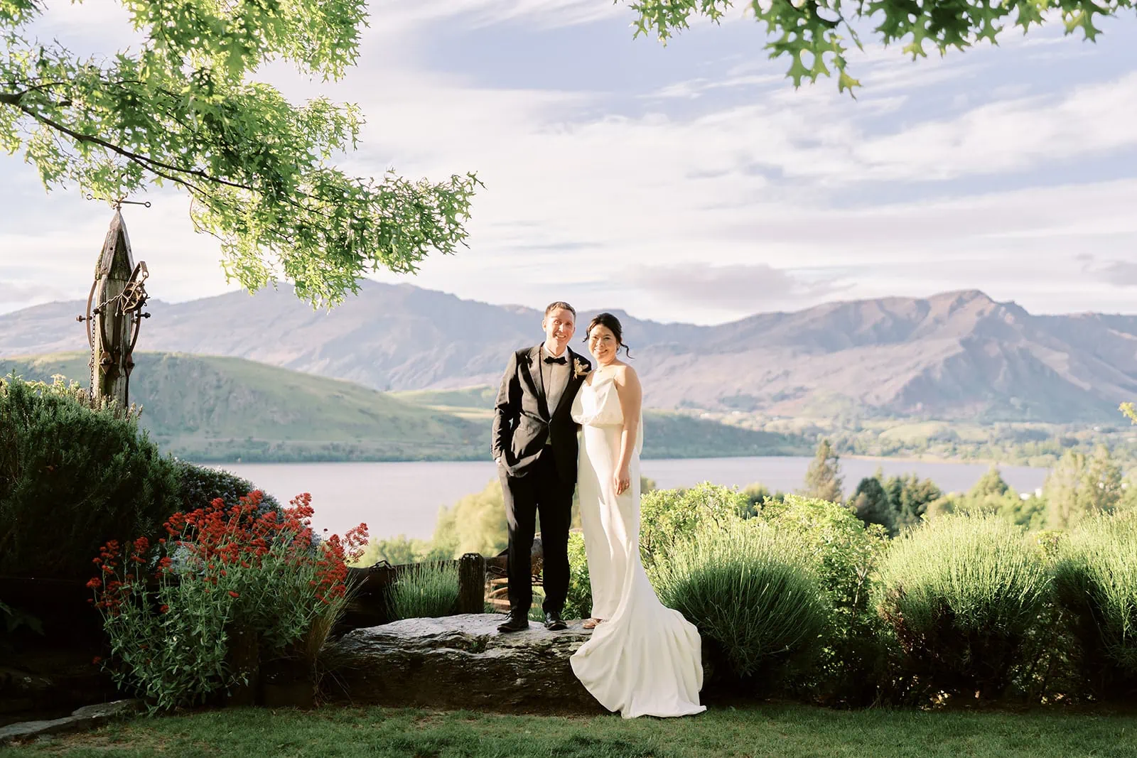 Queenstown Elopement Heli Wedding Photographer クイーンズタウン結婚式 | Wedding couple standing in front of Stoneridge Queenstown with mountains in the background.