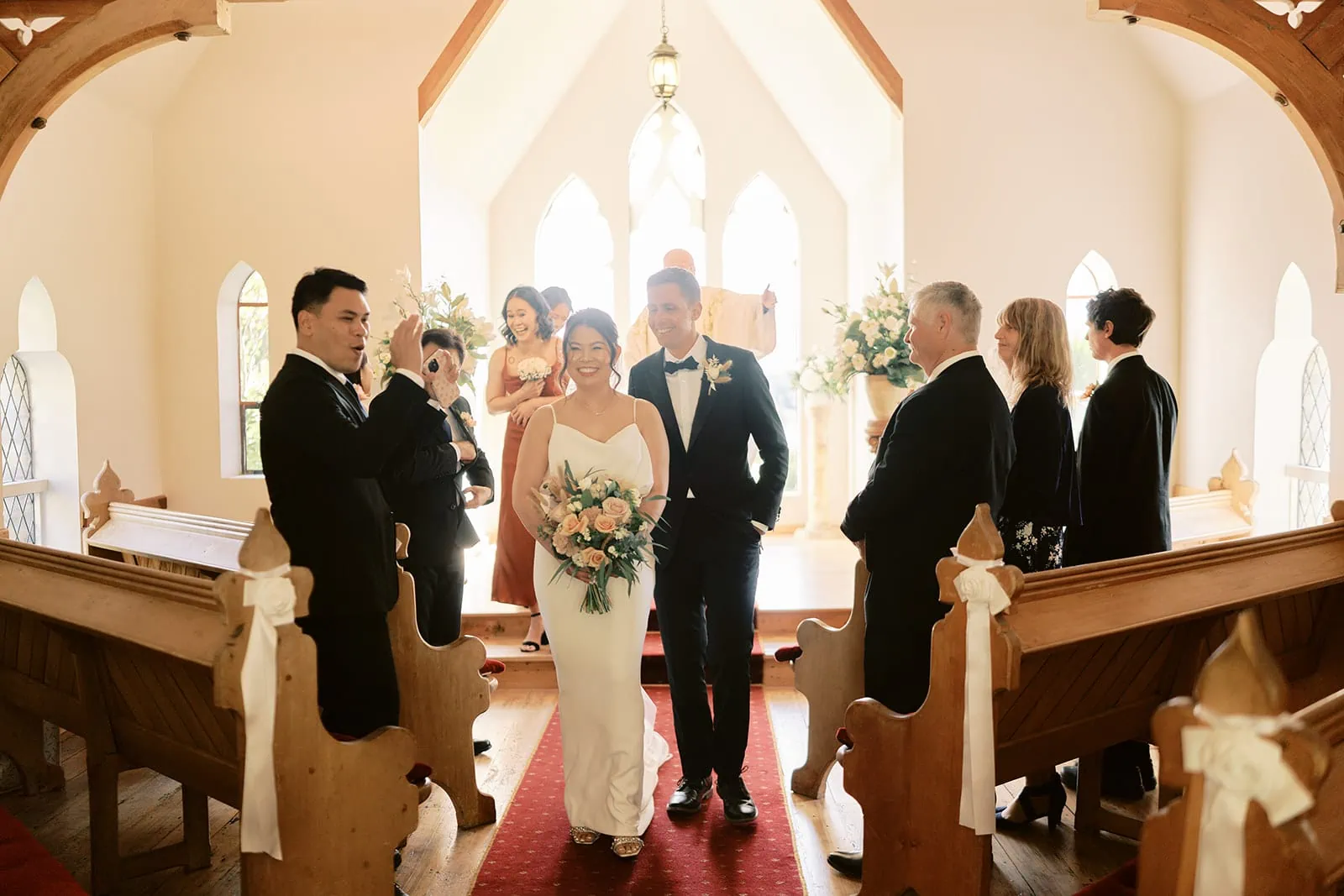 Queenstown Elopement Heli Wedding Photographer クイーンズタウン結婚式 | Shane and MJ, the bride and groom of the Stoneridge Queenstown Wedding, gracefully walk down the aisle of a charming church.
