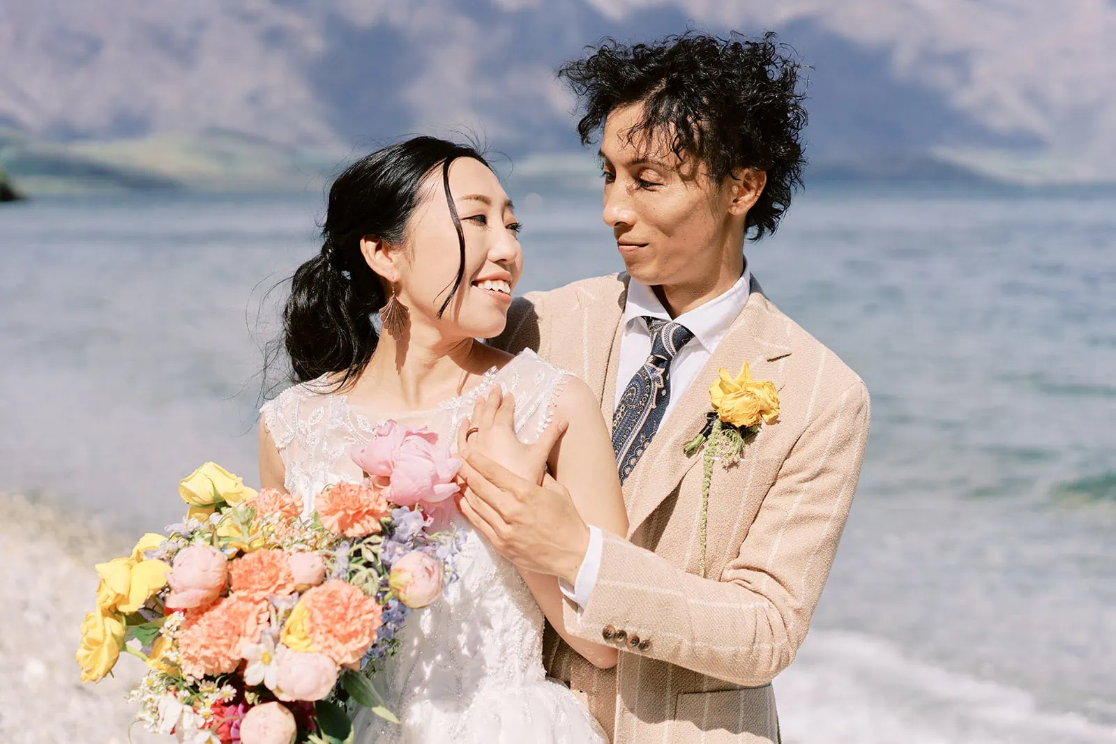 Queenstown Elopement Heli Wedding Photographer クイーンズタウン結婚式 | A Saki and Taisei, the Queenstown Heli Pre-Wedding Photoshoot couple, embracing on the beach.