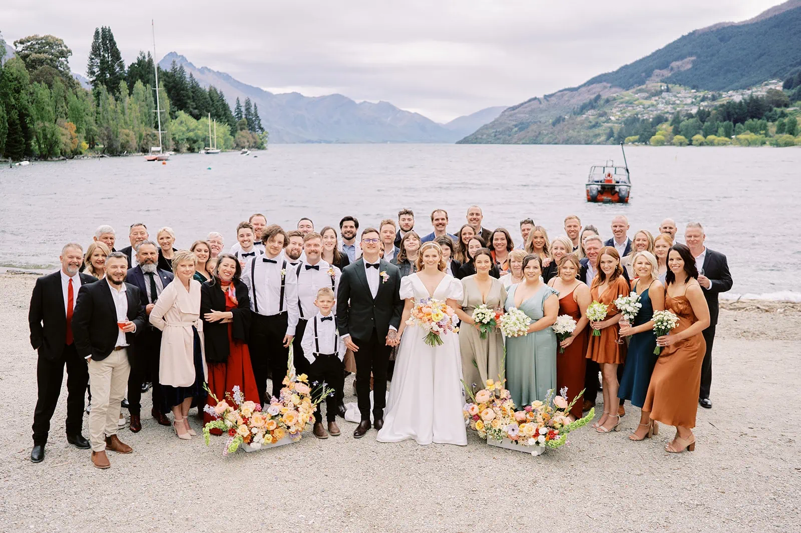 Queenstown Elopement Heli Wedding Photographer クイーンズタウン結婚式 | Thomas and Sophie, a Queenstown wedding party, posing for a photo in front of a lake.