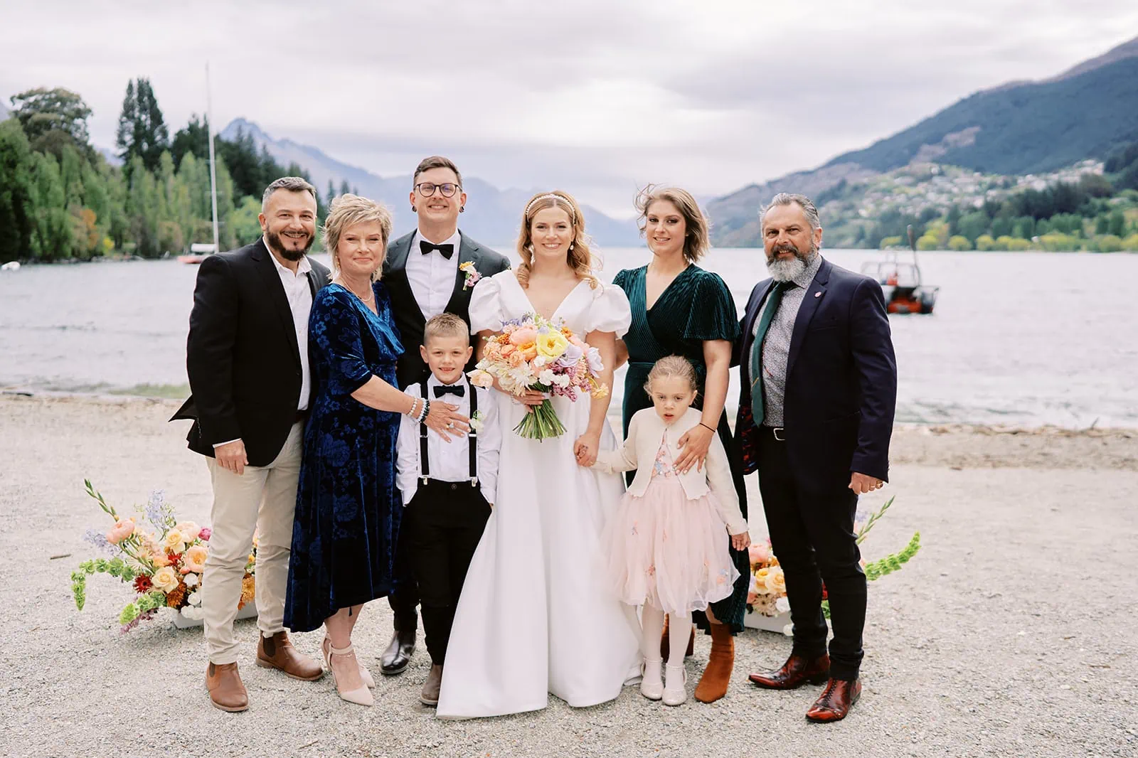 Queenstown Elopement Heli Wedding Photographer クイーンズタウン結婚式 | A family posing for a photo on the shore of Lake Wanaka during their Queenstown getaway.