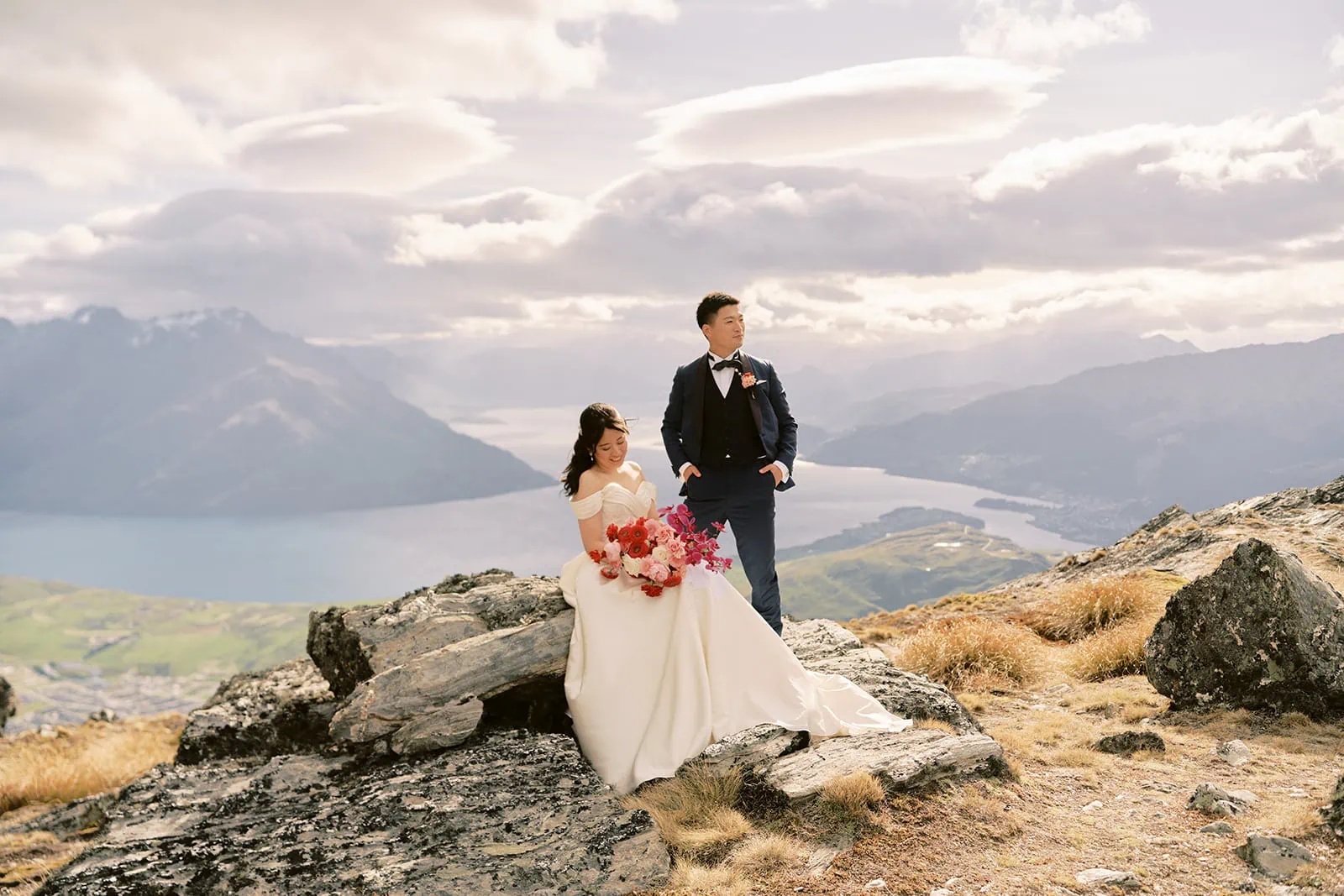 Queenstown Elopement Heli Wedding Photographer クイーンズタウン結婚式 | For their pre-wedding photoshoot, a bride and groom celebrate their love on top of a mountain overlooking stunning Lake Wanaka.