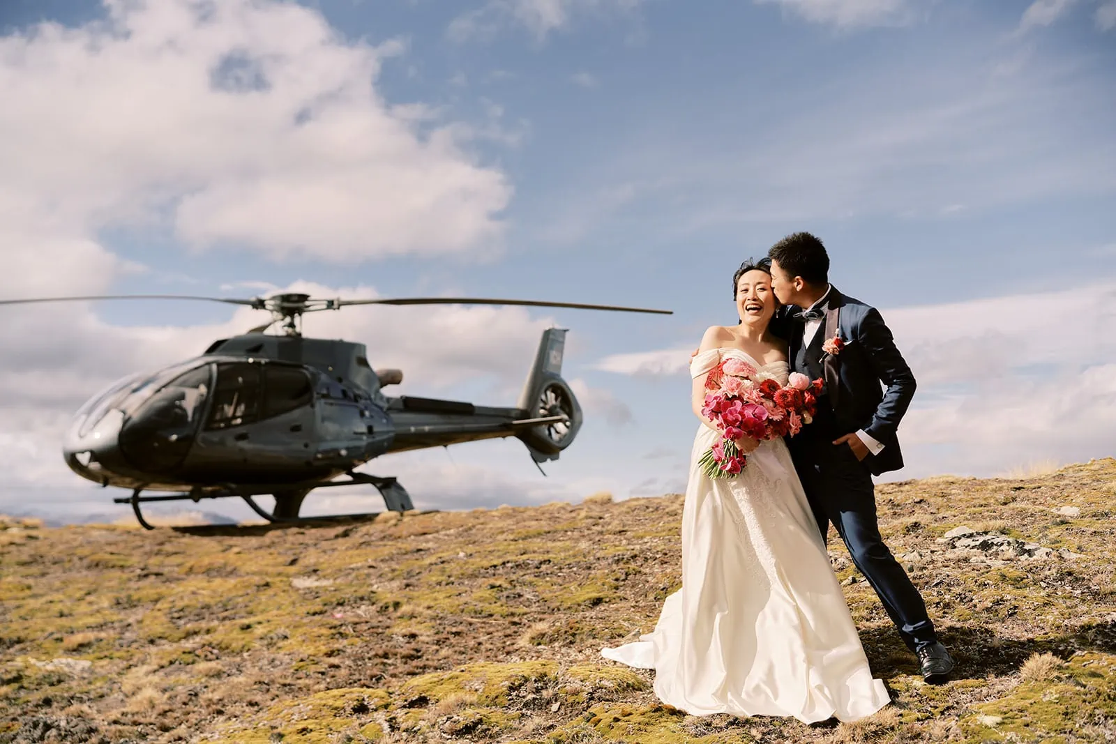 Queenstown Elopement Heli Wedding Photographer クイーンズタウン結婚式 | Pre-wedding photoshoot of a bride and groom standing in front of a helicopter.