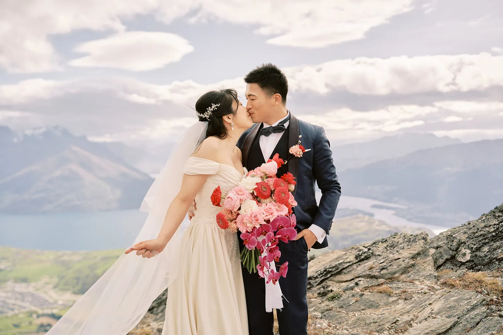 Queenstown Elopement Heli Wedding Photographer クイーンズタウン結婚式 | A romantic pre-wedding photoshoot capturing a bride and groom kissing on top of a mountain in Queenstown, New Zealand.