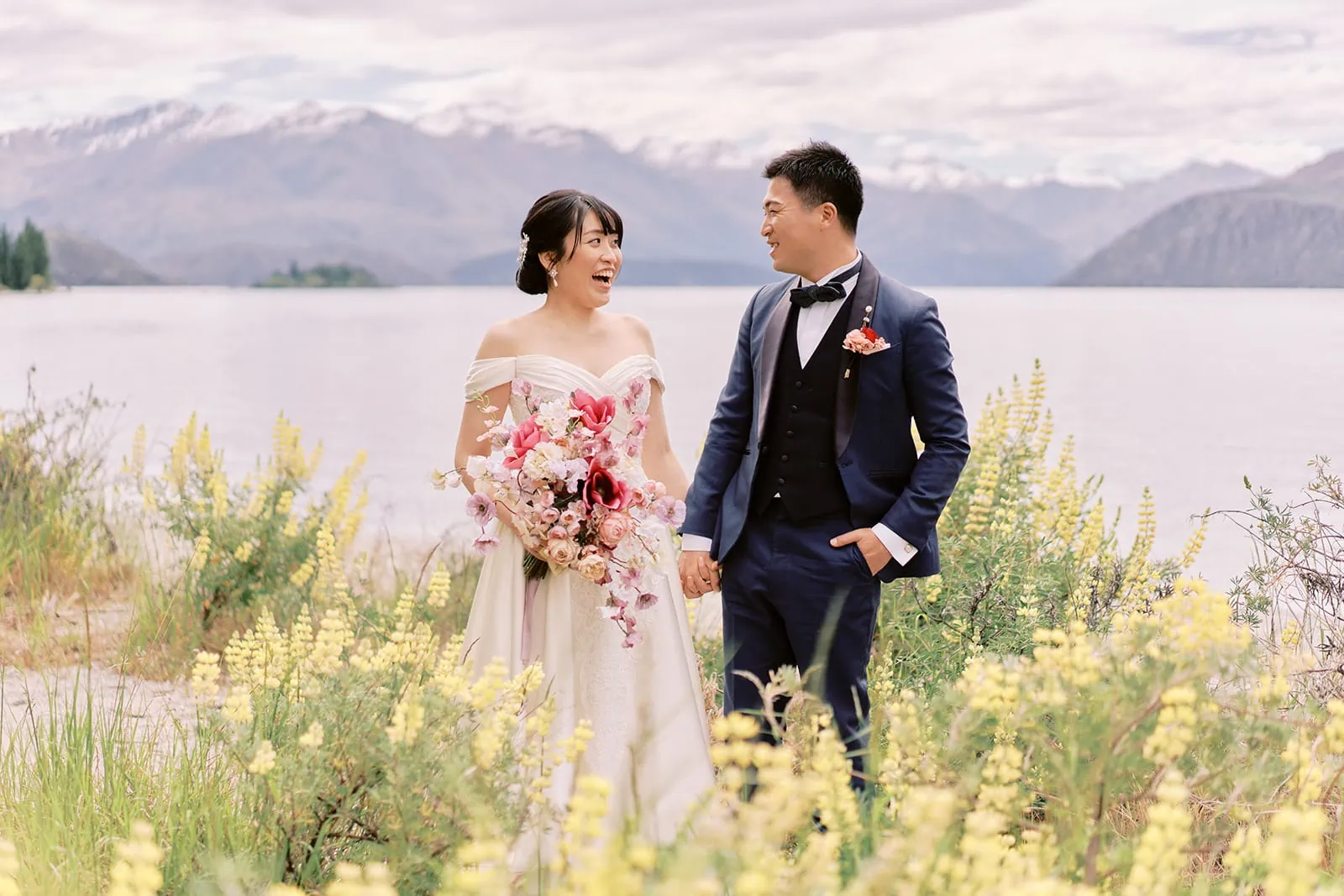 Queenstown Elopement Heli Wedding Photographer クイーンズタウン結婚式 | Pre-wedding photoshoot of a bride and groom standing in front of a lake in New Zealand.