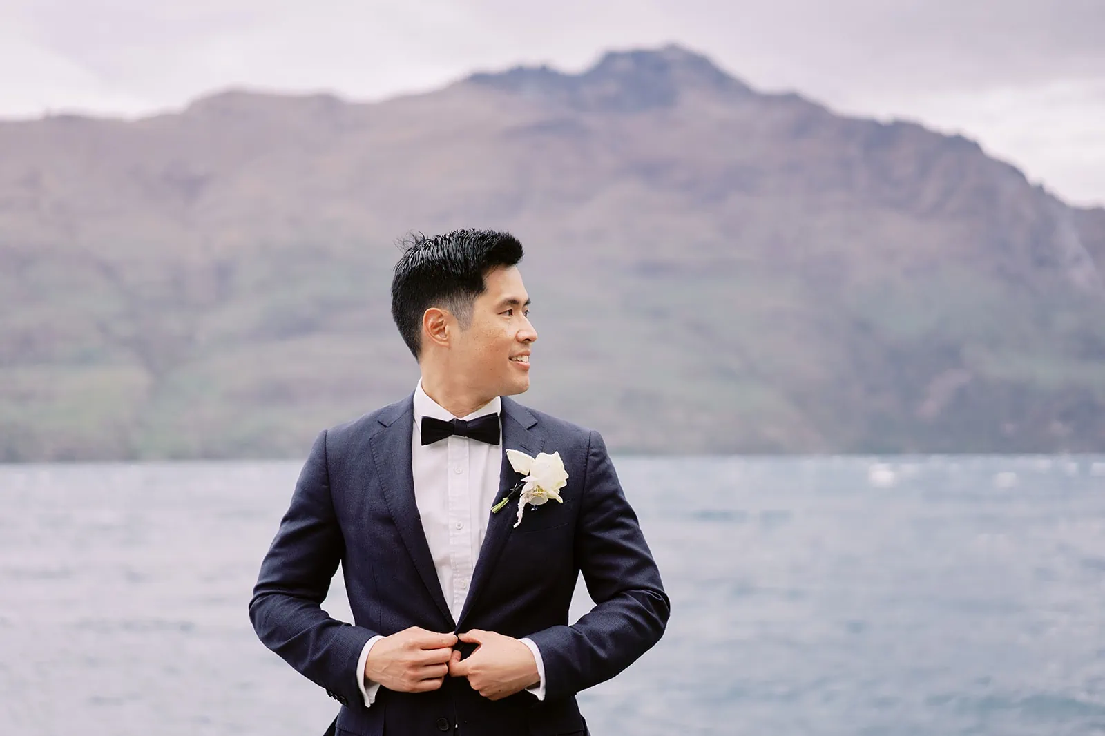 Queenstown Elopement Heli Wedding Photographer クイーンズタウン結婚式 | A man in a suit and bow tie looks dapper for his pre-wedding photoshoot.