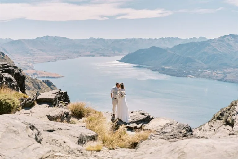 Queenstown New Zealand Heli Wedding Elopement Photographer クイーンズタウン　ニュージーランド　エロープメント 結婚式 | Sarah & Anton embracing on a mountain overlooking scenic Moke Lake.