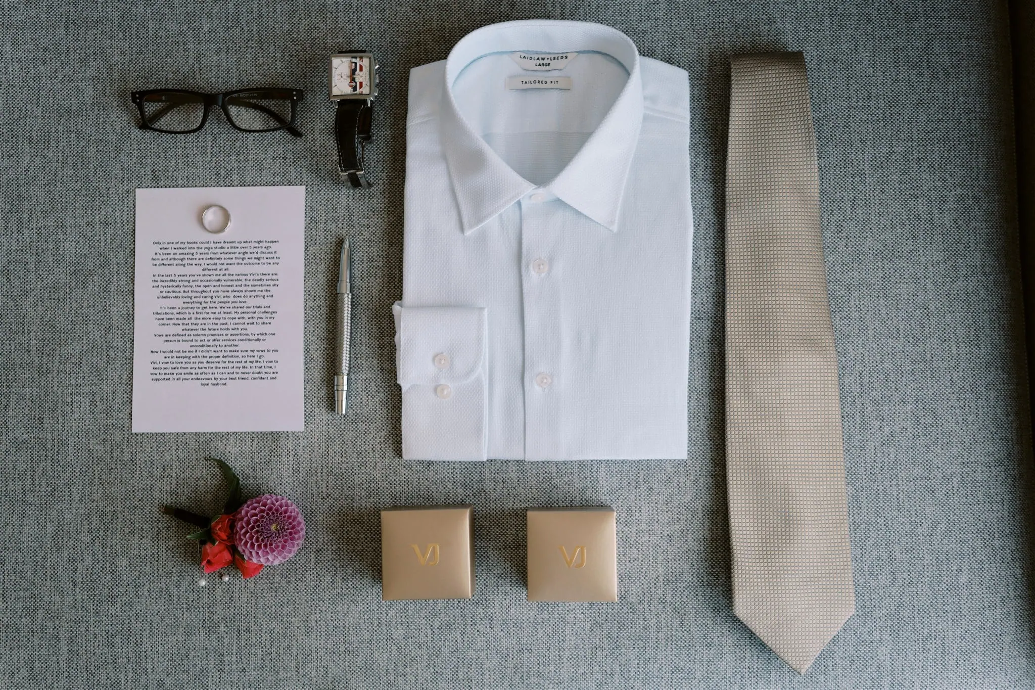queenstown new zealand heli wedding elopement photographer videographer | A flat lay of a man's wedding attire including a white shirt, tie, glasses, cufflinks, pen, boutonniere, and two wedding vow booklets on a gray background for an elopement photography session.

Keywords Selected: elopement photography